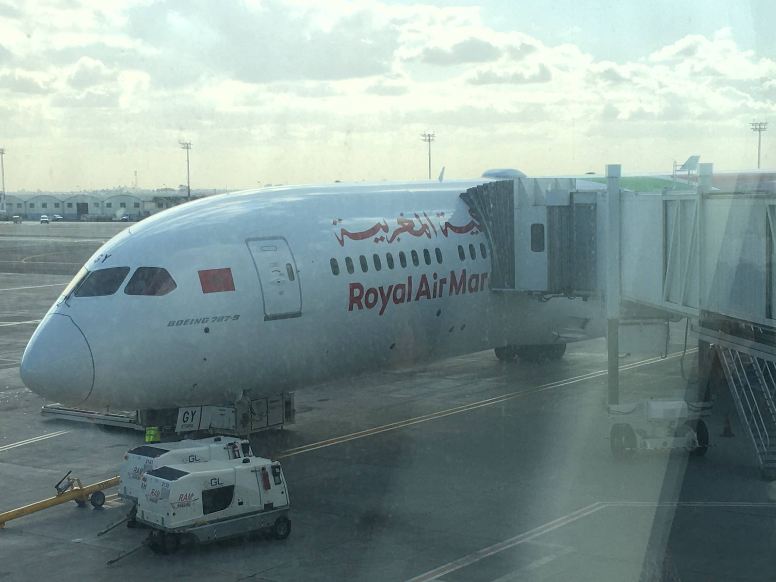 飛機 桌布 壁紙 — 一架皇家摩洛哥航空波音787停泊在機場閘口，連接了登機橋，天空多雲。
