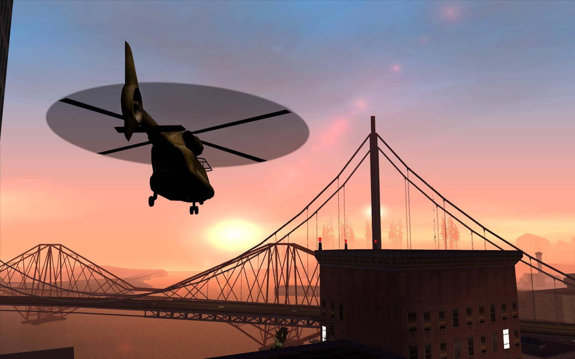 GTA 聖安地列斯 桌布 壁紙 — 一架直升機在日落時分盤旋在城市橋樑上空，在溫暖的橙色天空中投下長長的影子。