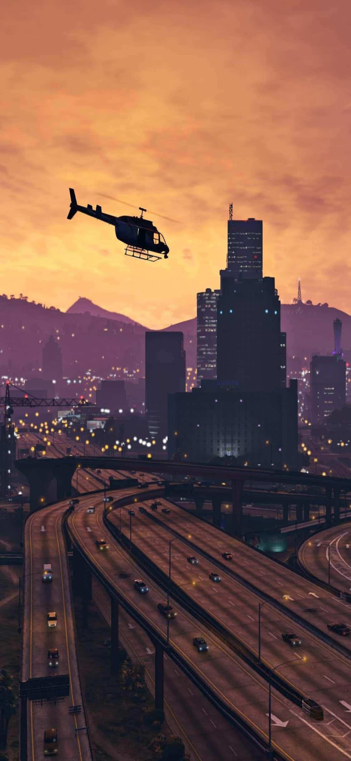 Helicopter 桌布 壁紙 — 一架直升機在日落時分飛越廣闊的城市景觀，有發光的高速公路和高聳的摩天大樓。