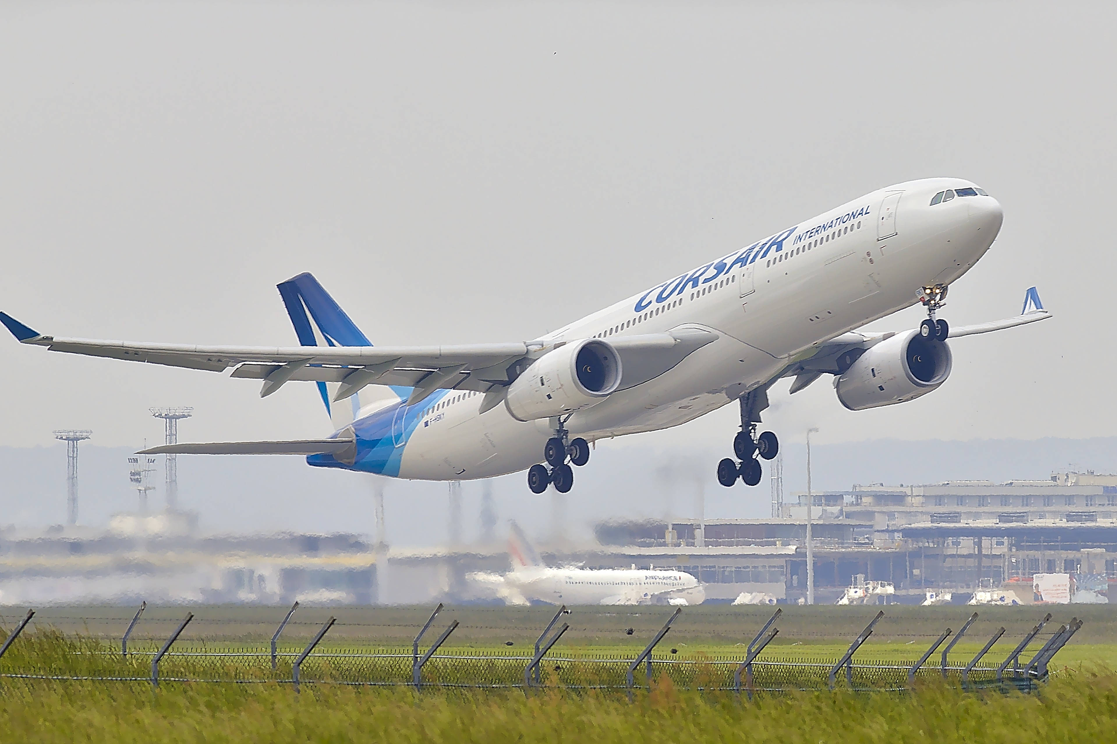 Aerospace 桌布 壁紙 — 一架科西嘉國際航空的空中巴士A330從跑道起飛，起落架仍伸出，背景是朦朧的天空。