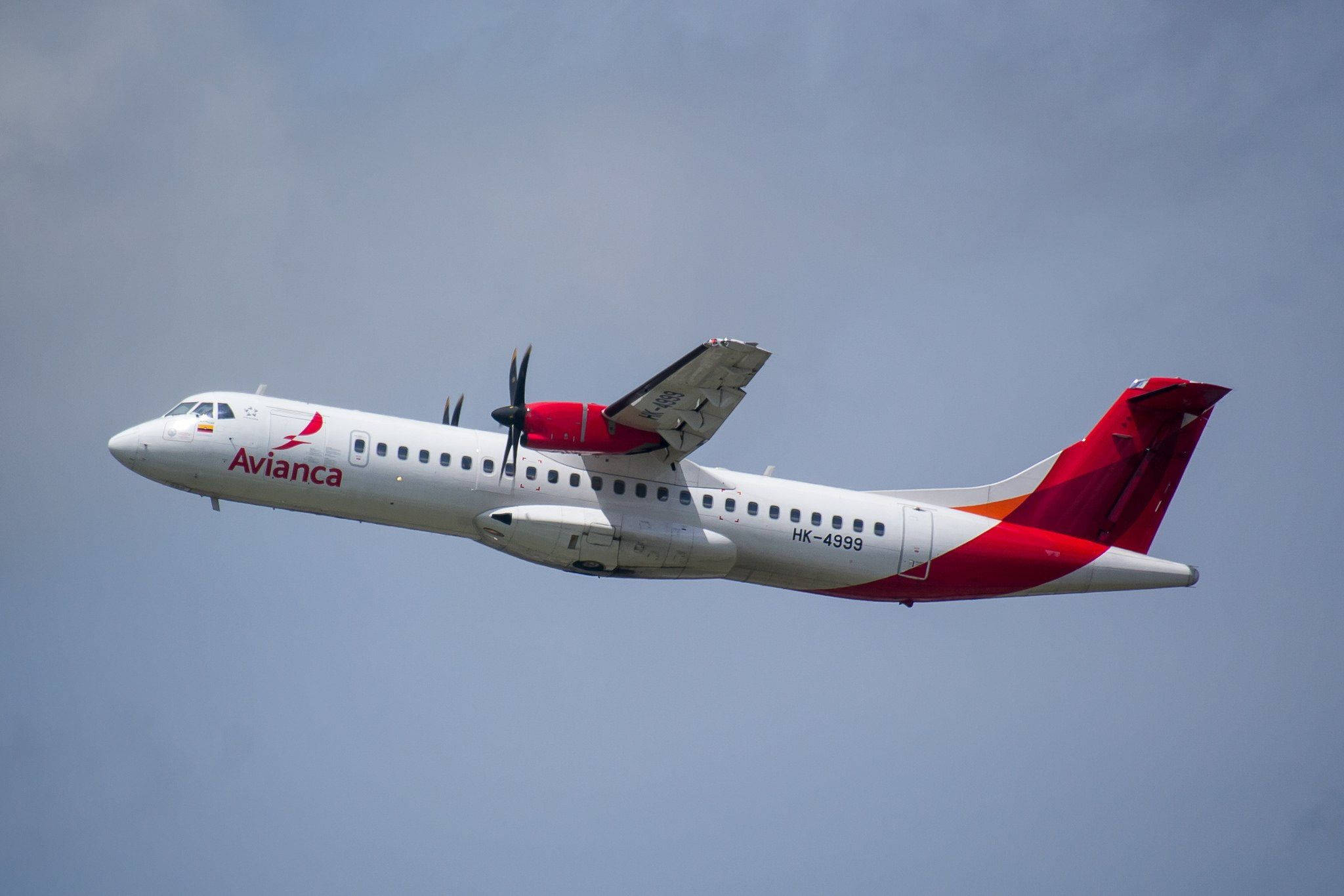 Plane 桌布 壁紙 — 一架紅白塗裝的 Avianca 渦輪螺旋槳飛機在雲層密佈的天空中翱翔。