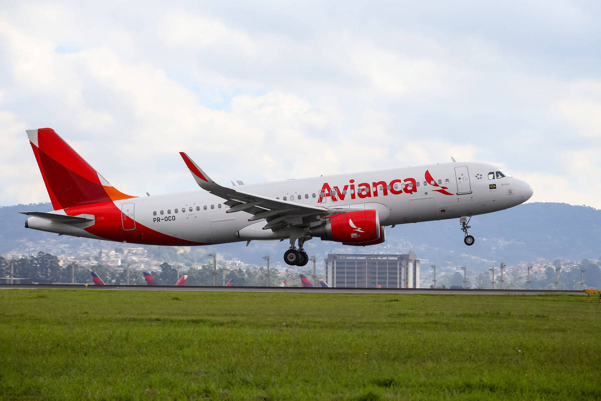 Plane 桌布 壁紙 — 一架紅白塗裝的Avianca飛機在陰天、綠草和遠山背景下從跑道起飛。