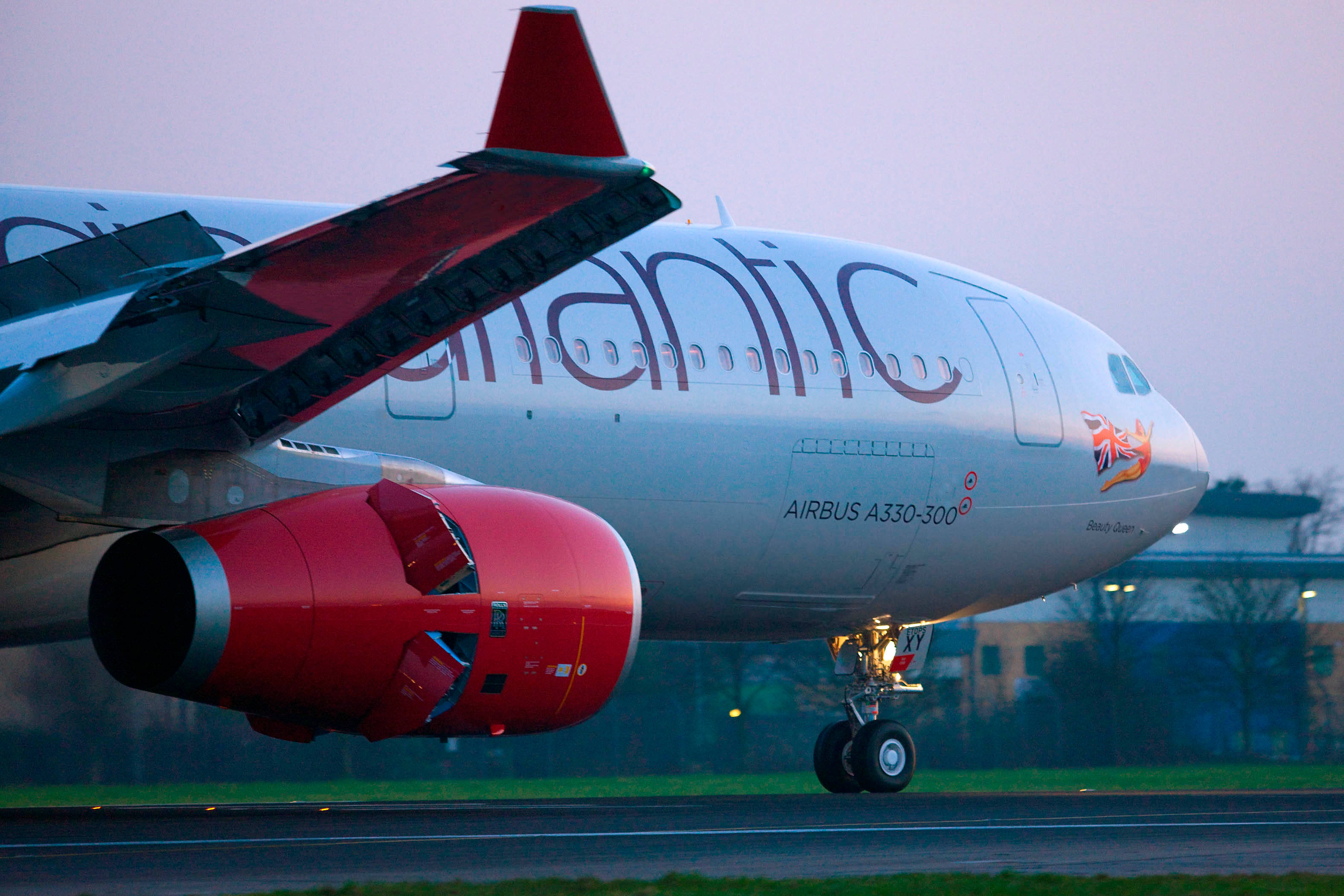 飛機 桌布 壁紙 — 一架紅白相間的Atlantic Airways Airbus A330-300飛機在黃昏時分，在柔和的環境燈光下滑行在跑道上。
