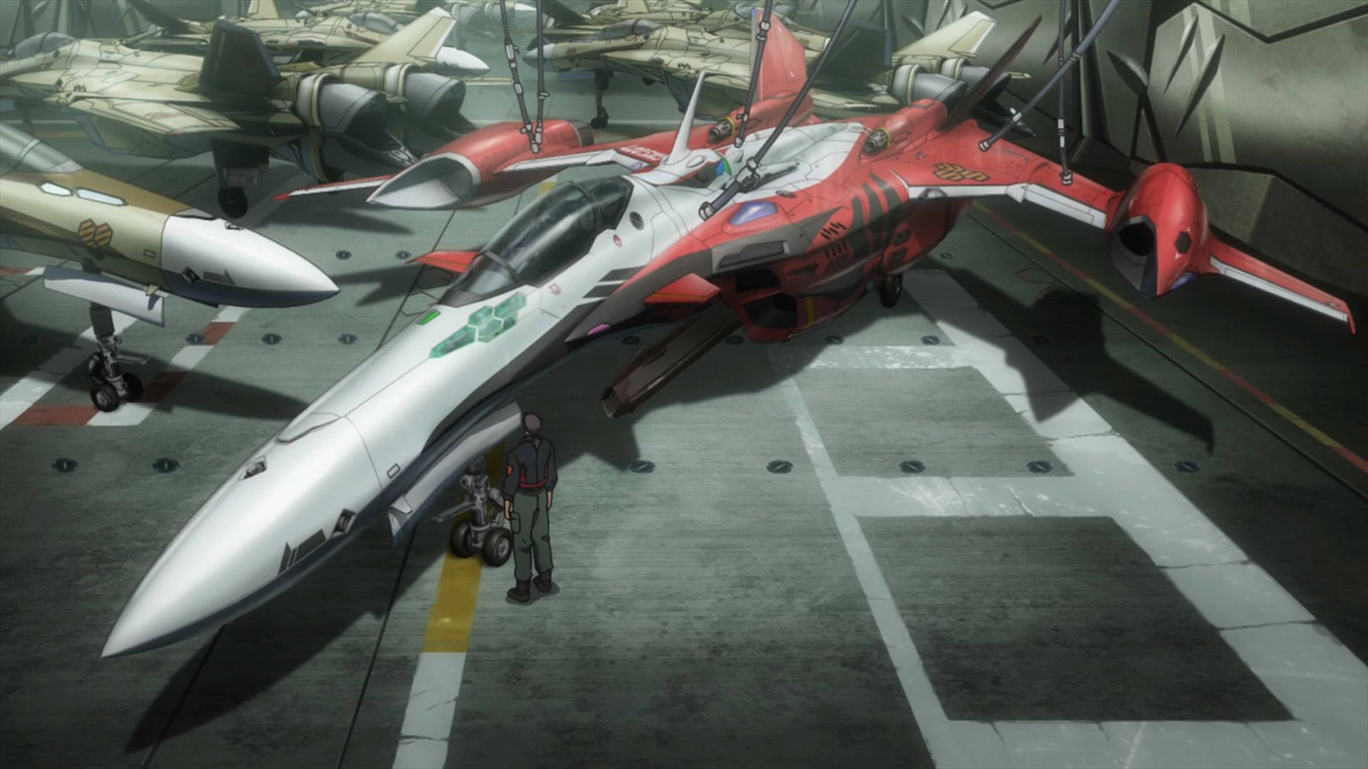 Macross 桌布 壁紙 — 一架紅白相間的戰鬥機佔據了機庫地面，一個小人影站在它旁邊，周圍還有其他飛機。