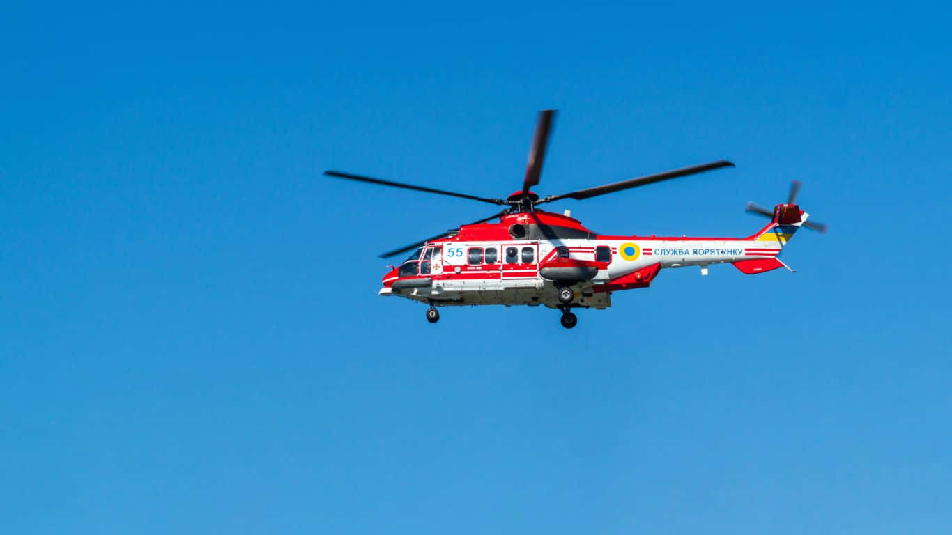1366x768 Helicopters 桌布 壁紙 — 一架紅白相間的救援直升機在晴朗的藍天中翱翔，螺旋槳旋轉。