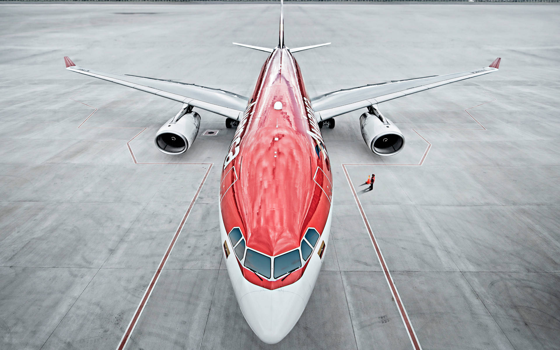 Plane 桌布 壁紙 — 一架紅白相間的飛機停泊在灰色停機坪上的鳥瞰圖，附近有一名孤獨的地勤人員。