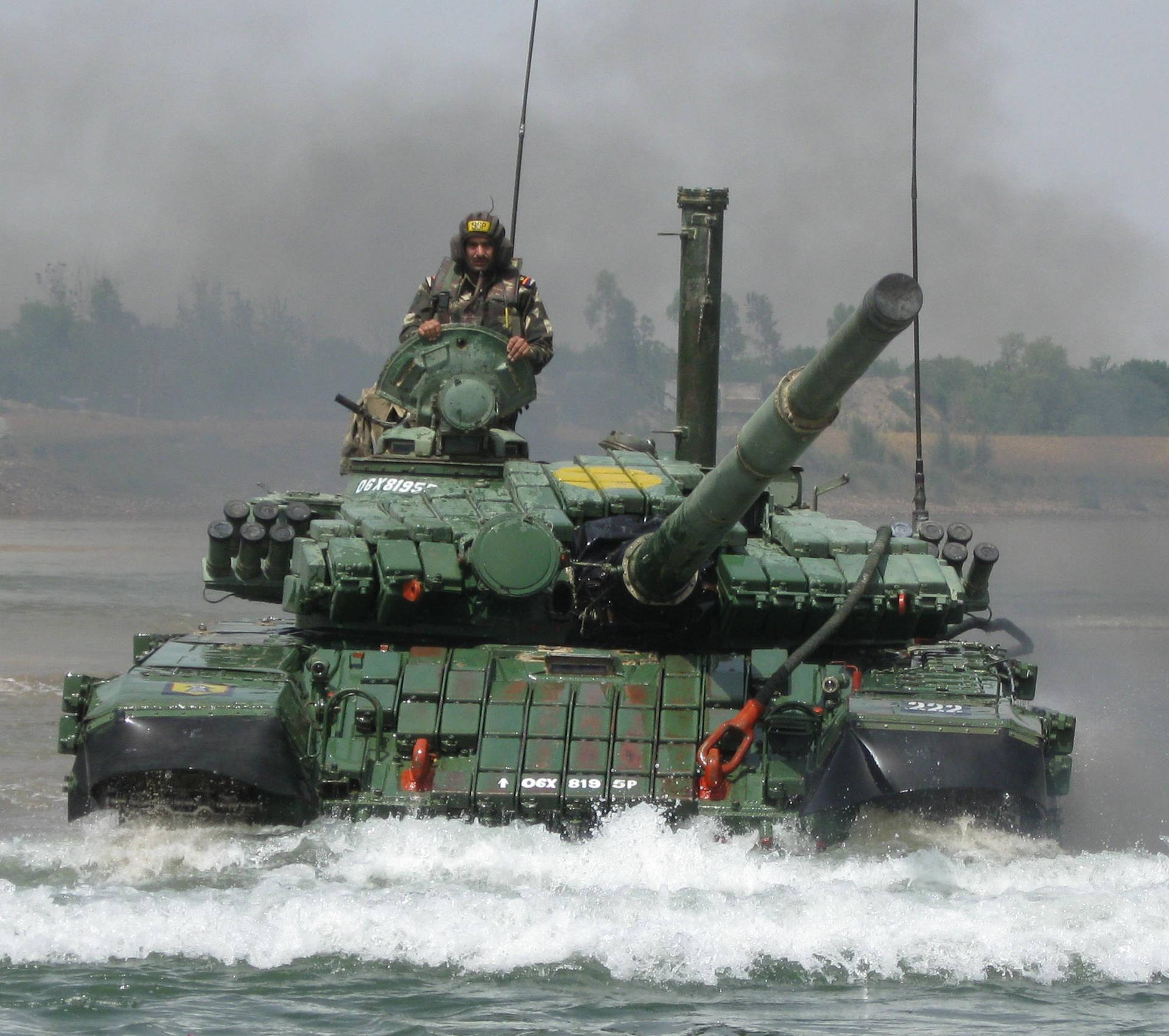 一架綠色軍用坦克，上面載著一名士兵，在水中移動。 — 印度軍隊 壁紙