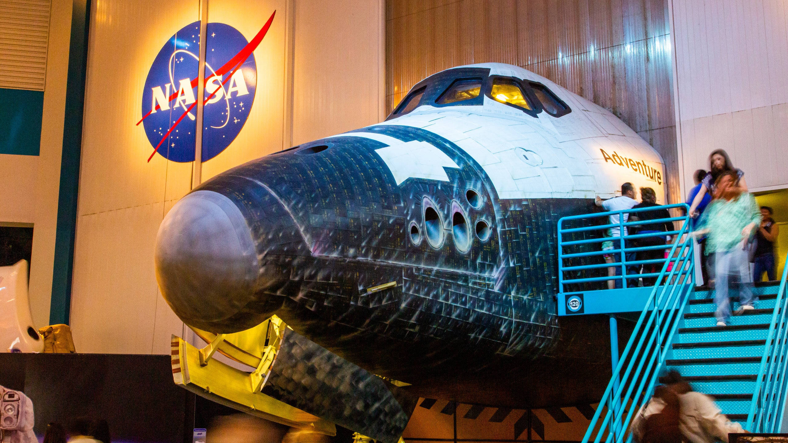 NASA 動態圖片 桌布 壁紙 — 一架美國太空總署太空梭在博物館展出，參觀者爬上樓梯觀看其駕駛艙。