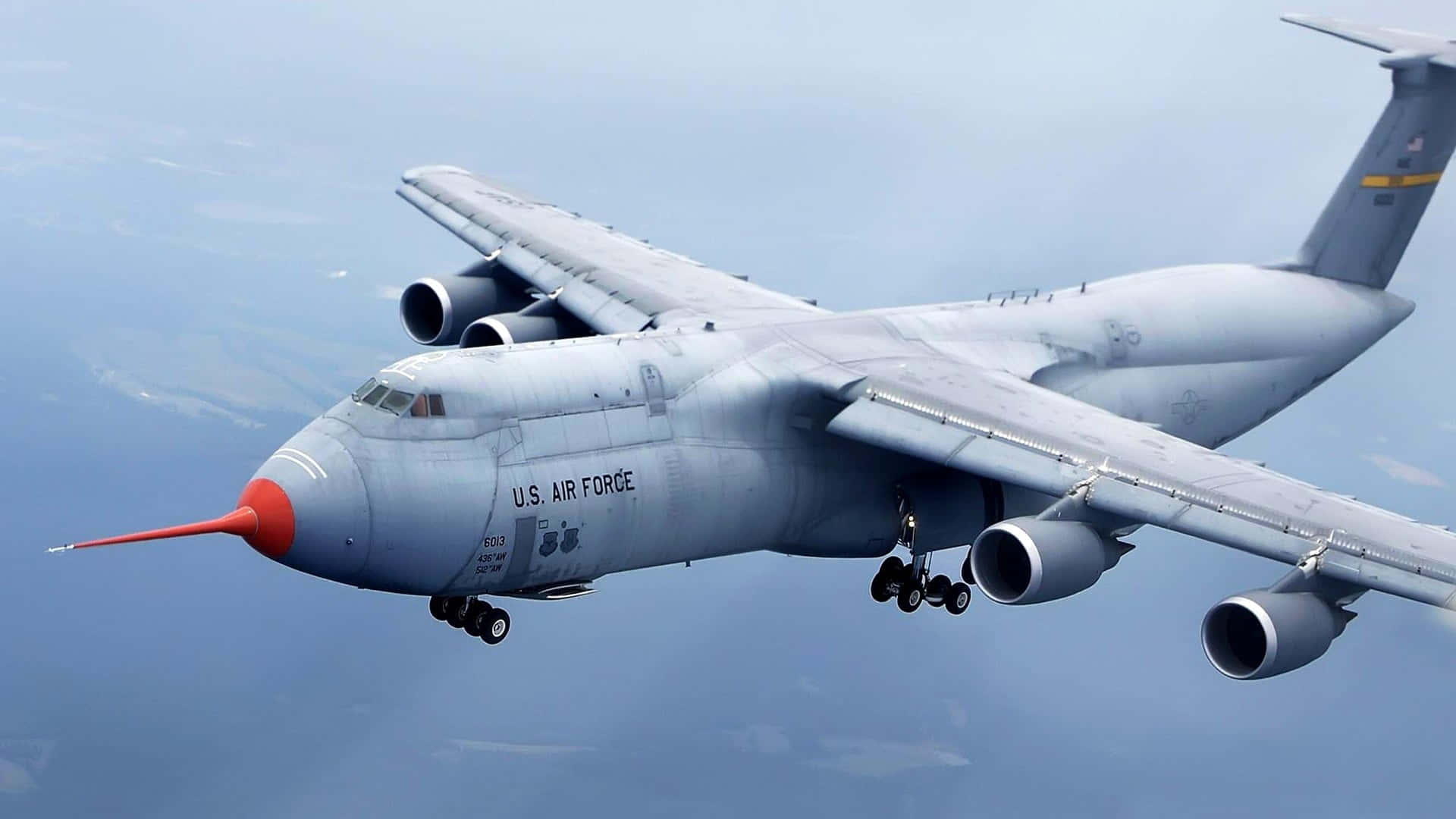 Jumbo Jets 桌布 壁紙 — 一架美國空軍C-17環球霸王III軍用運輸機在藍天和遠方陸地上空低飛，起落架放下。