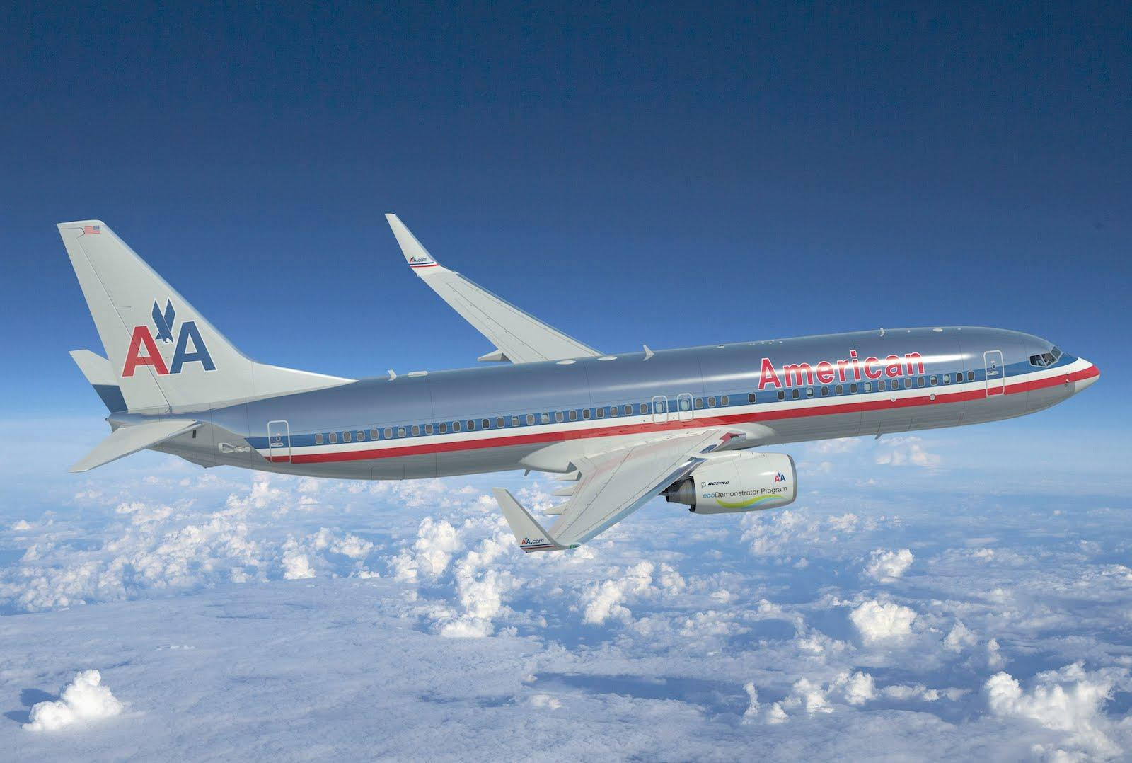 Airlines 桌布 壁紙 — 一架美國航空噴射機在晴朗藍天下翱翔於蓬鬆白雲之上。