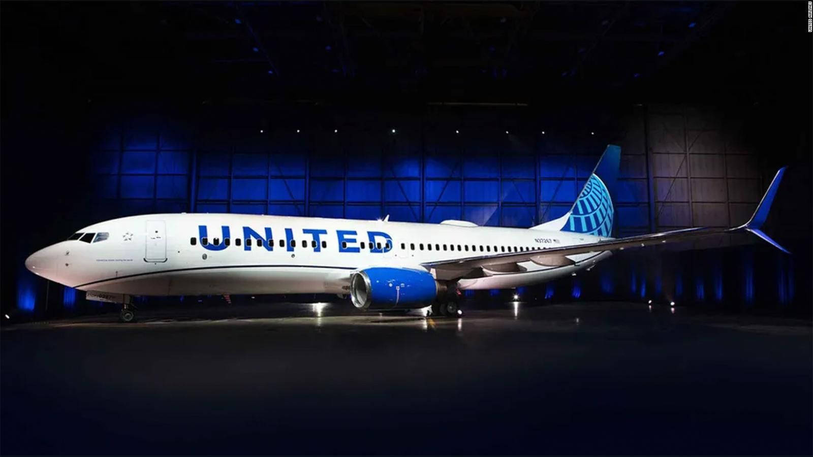 Airport 桌布 壁紙 — 一架聯合航空波音737在黑暗的機庫中被戲劇性地照亮，藍色重點照明突出了其流線型的白色機身和藍色引擎。