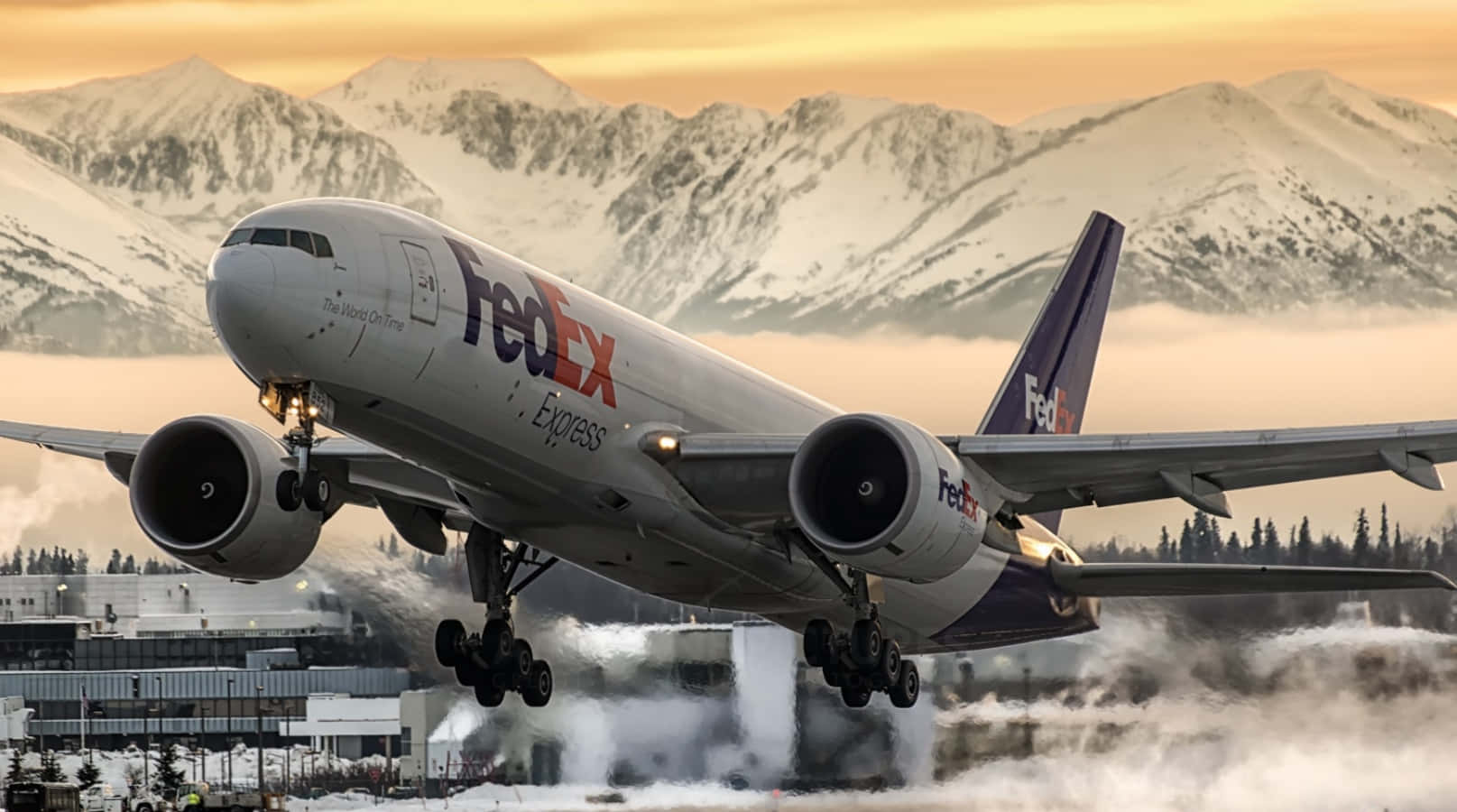 聯邦快遞 桌布 壁紙 — 一架聯邦快遞Express飛機在黃金時段降落在白雪覆蓋的山脈背景下。