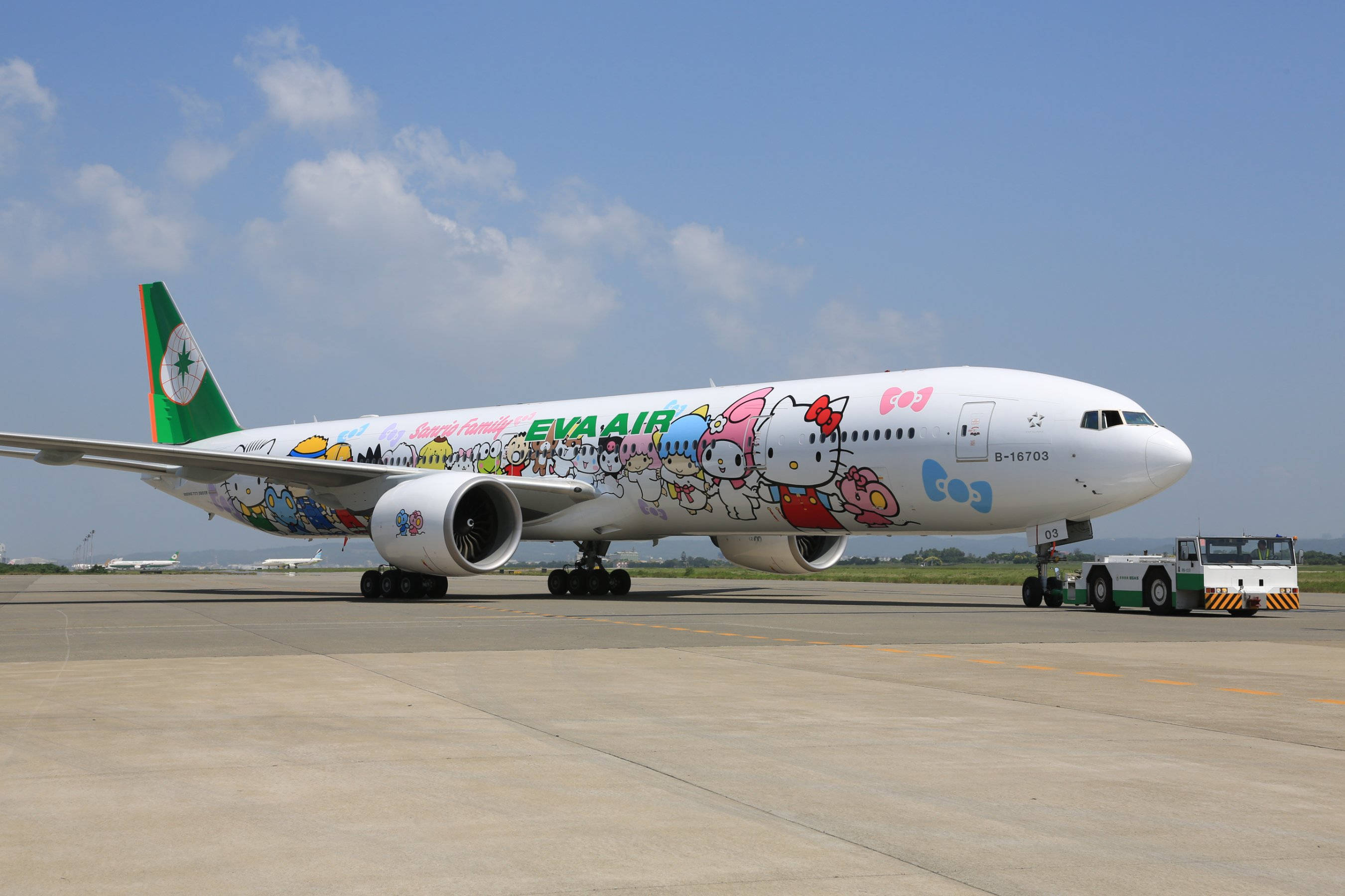 Airport 桌布 壁紙 — 一架色彩繽紛的Hello Kitty塗裝飛機停在陽光明媚的機場停機坪上，藍天白雲。
