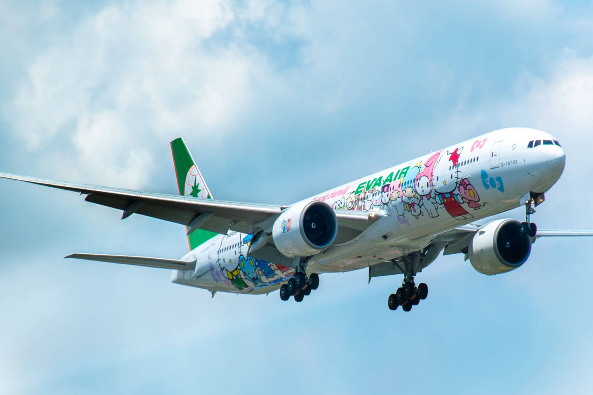 transportation 桌布 壁紙 — 一架色彩繽紛的長榮航空飛機，飾有Hello Kitty角色，在晴朗的藍天和蓬鬆的白雲中飛行。