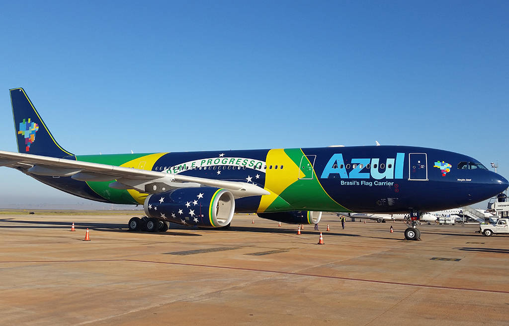 帶有巴西國旗塗裝的Azul Airlines飛機停在強烈陽光下的機場停機坪。 — 深藍色 GIF 壁紙