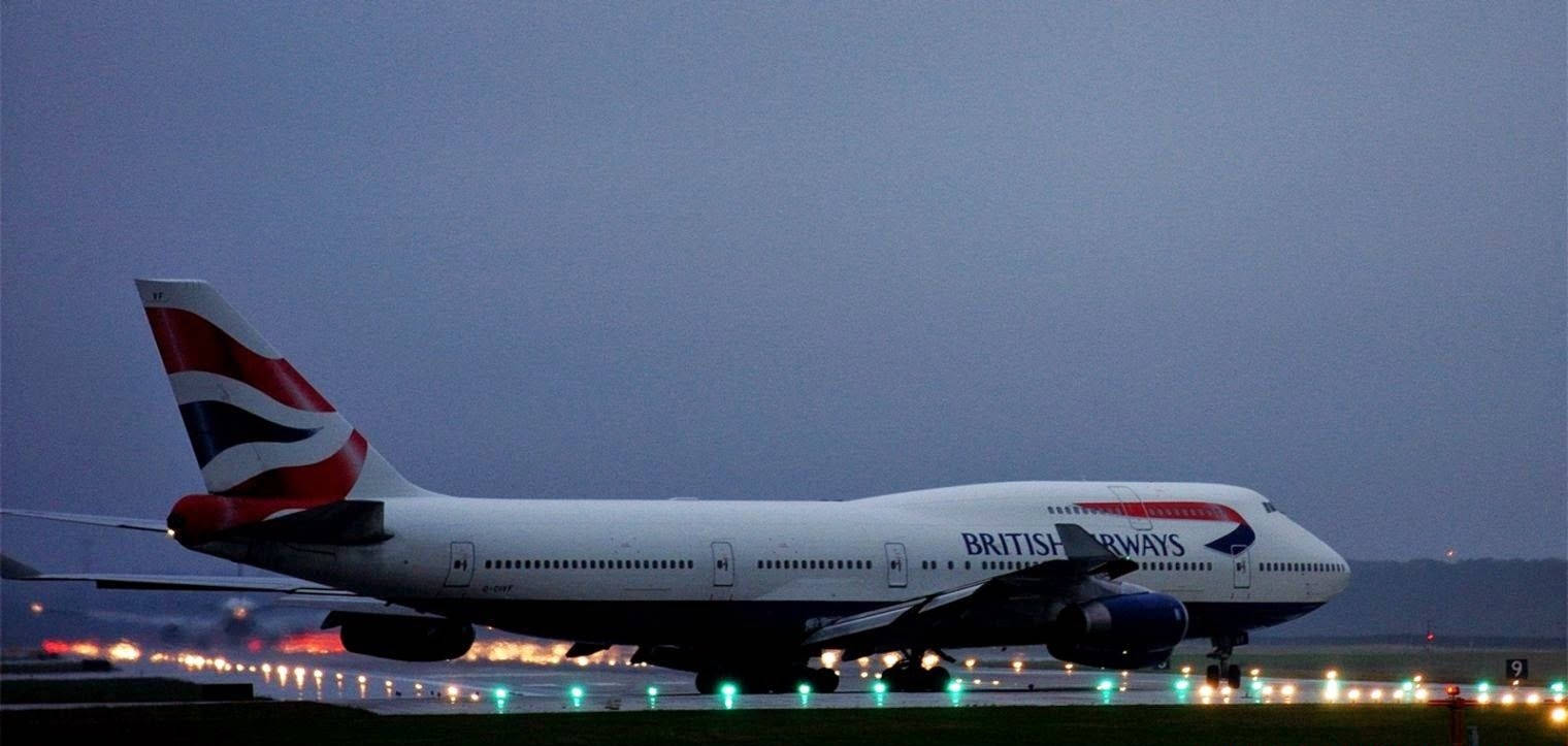 Plane 桌布 壁紙 — 一架英國航空波音747在黃昏時分在跑道上滑行，停機坪上排列著發光的燈光。