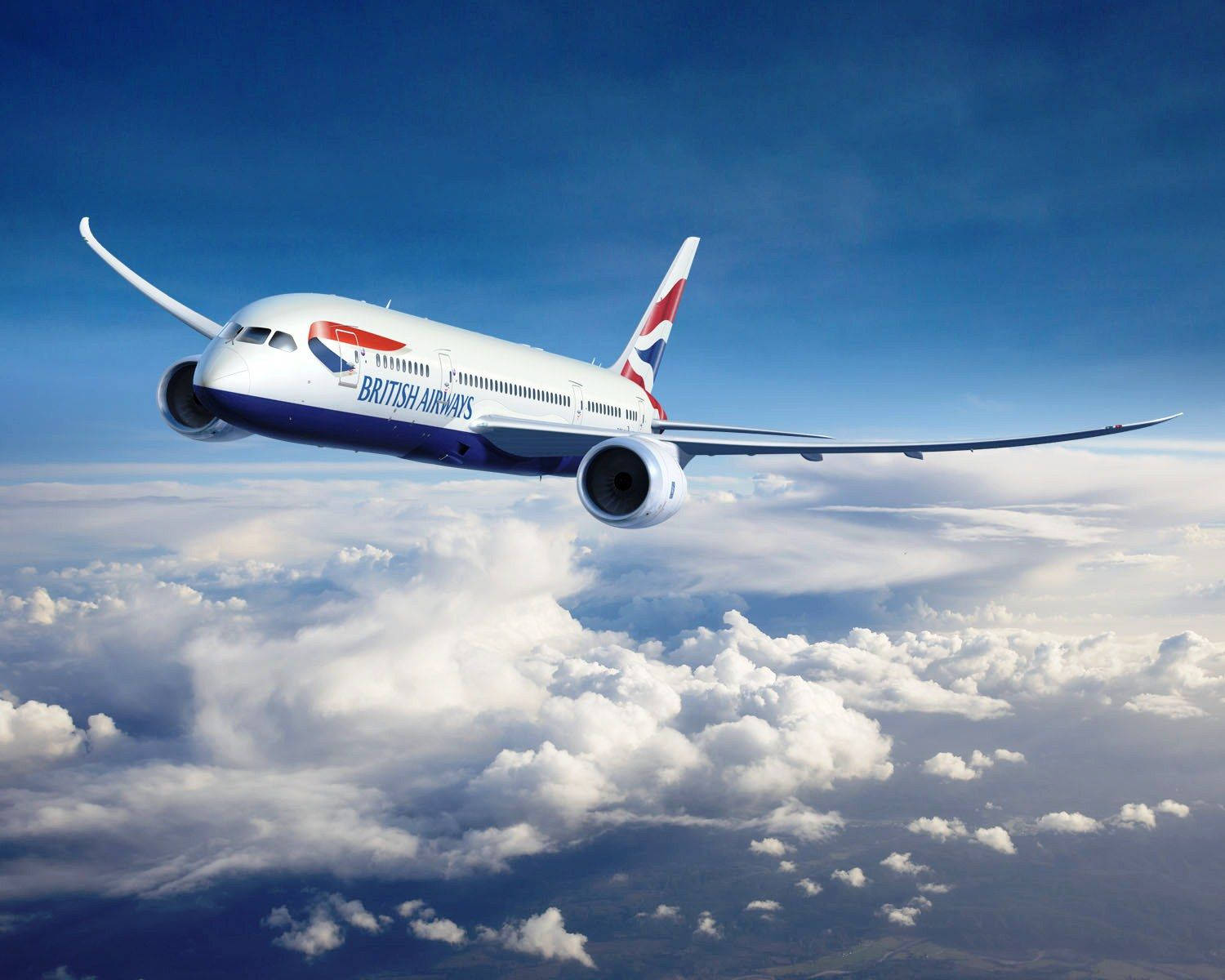 飛機 桌布 壁紙 — 一架英國航空飛機在晴朗的藍天下優雅地翱翔於蓬鬆的白雲之上。