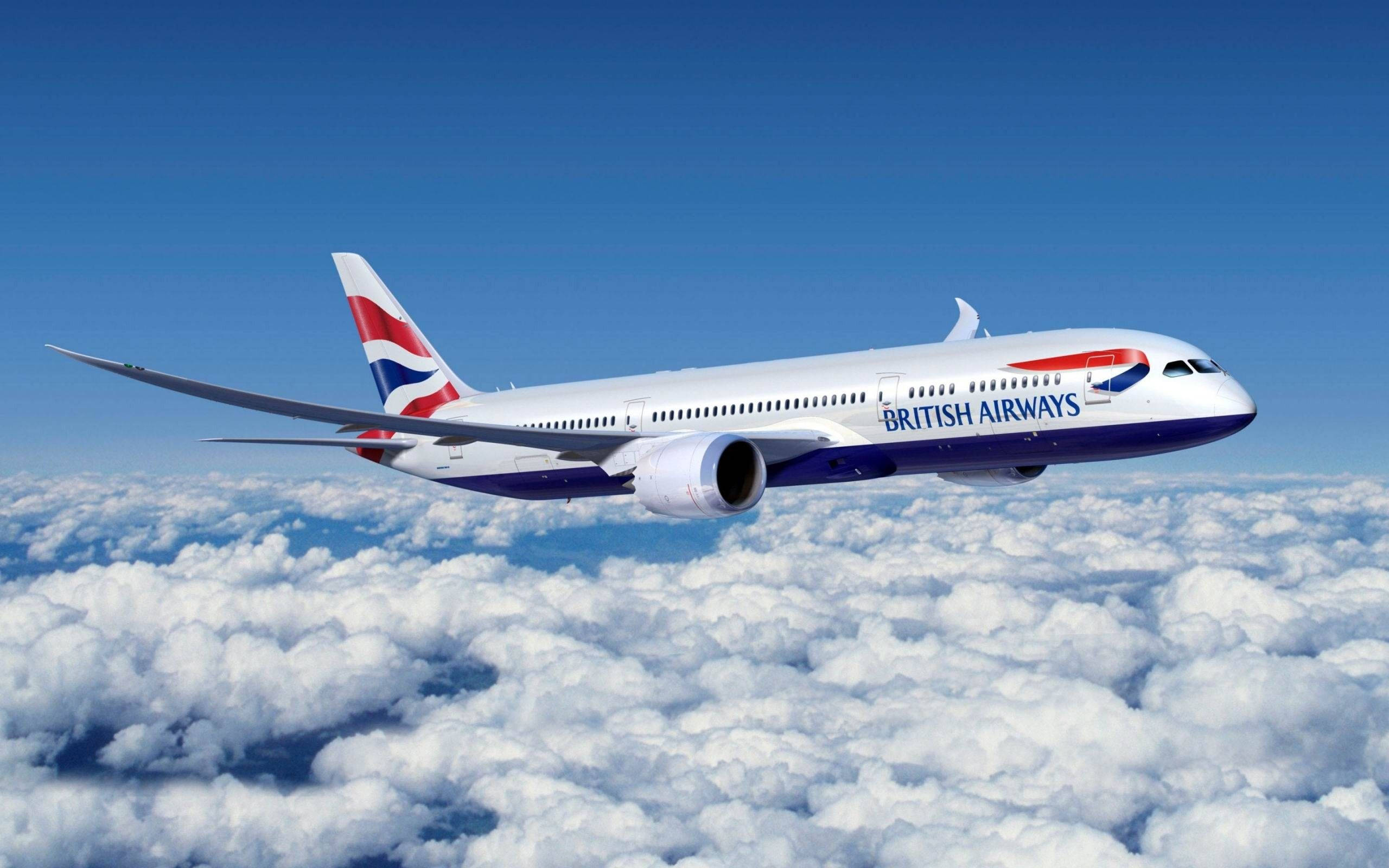 飛機 桌布 壁紙 — 一架英國航空飛機在晴朗藍天下，優雅地翱翔於大片蓬鬆白雲之上。