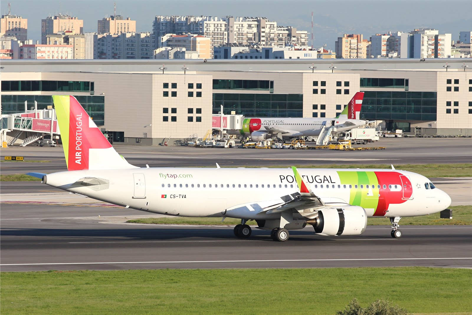 Airport 桌布 壁紙 — 一架葡萄牙航空的空中巴士A320正在跑道上滑行，背景是現代化的機場航廈和城市天際線。