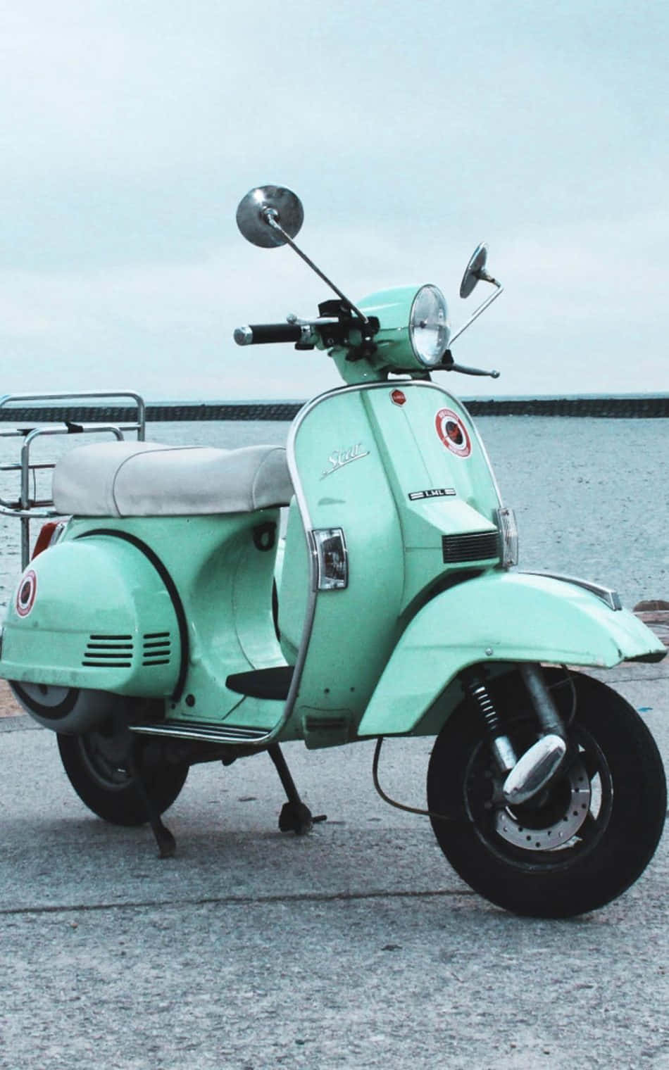 腳踏車 桌布 壁紙 — 一架薄荷綠色復古機車停放在混凝土碼頭上，俯瞰著陰天下的平靜水面。