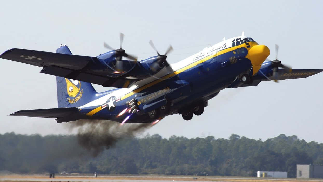US Navy 桌布 壁紙 — 一架藍天使C-130大力神飛機以藍、黃、白色塗裝，在跑道上低空飛過，後燃器轟鳴。