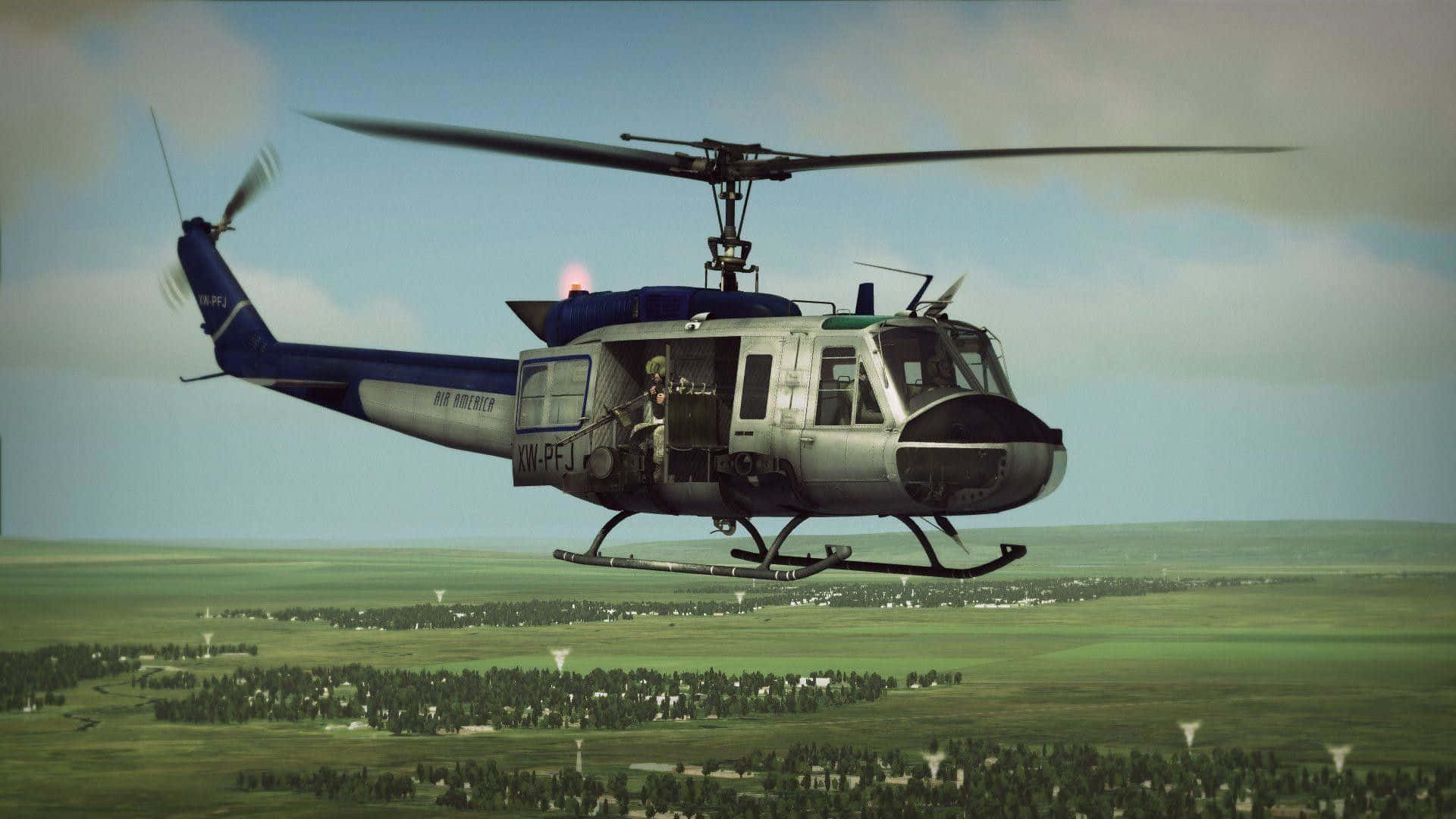 Helicopter 桌布 壁紙 — 一架藍銀色的軍用直升機在多雲的天空下低空盤旋於廣闊的綠色鄉村上空。