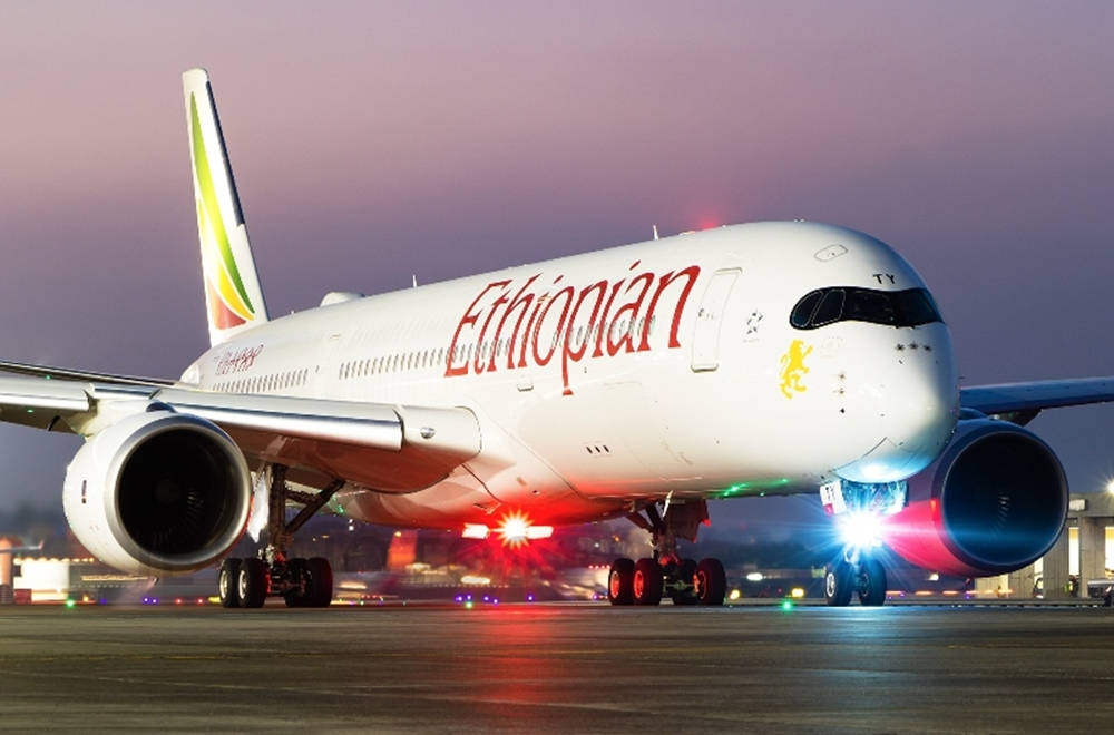  壁紙 — 一架衣索比亞航空的飛機在紫色天空下的黃昏時分，亮著燈光在跑道上滑行。