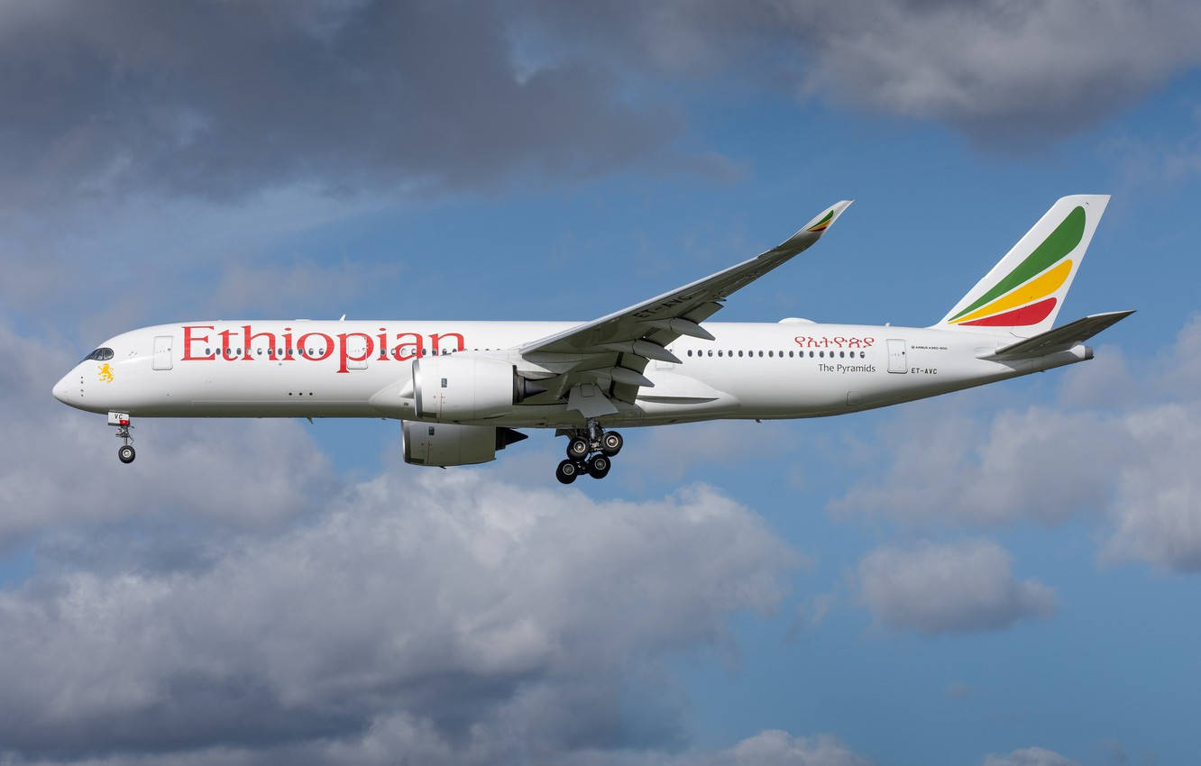 飛機 桌布 壁紙 — 一架衣索比亞航空的飛機放下起落架，在部分多雲的藍天中翱翔。