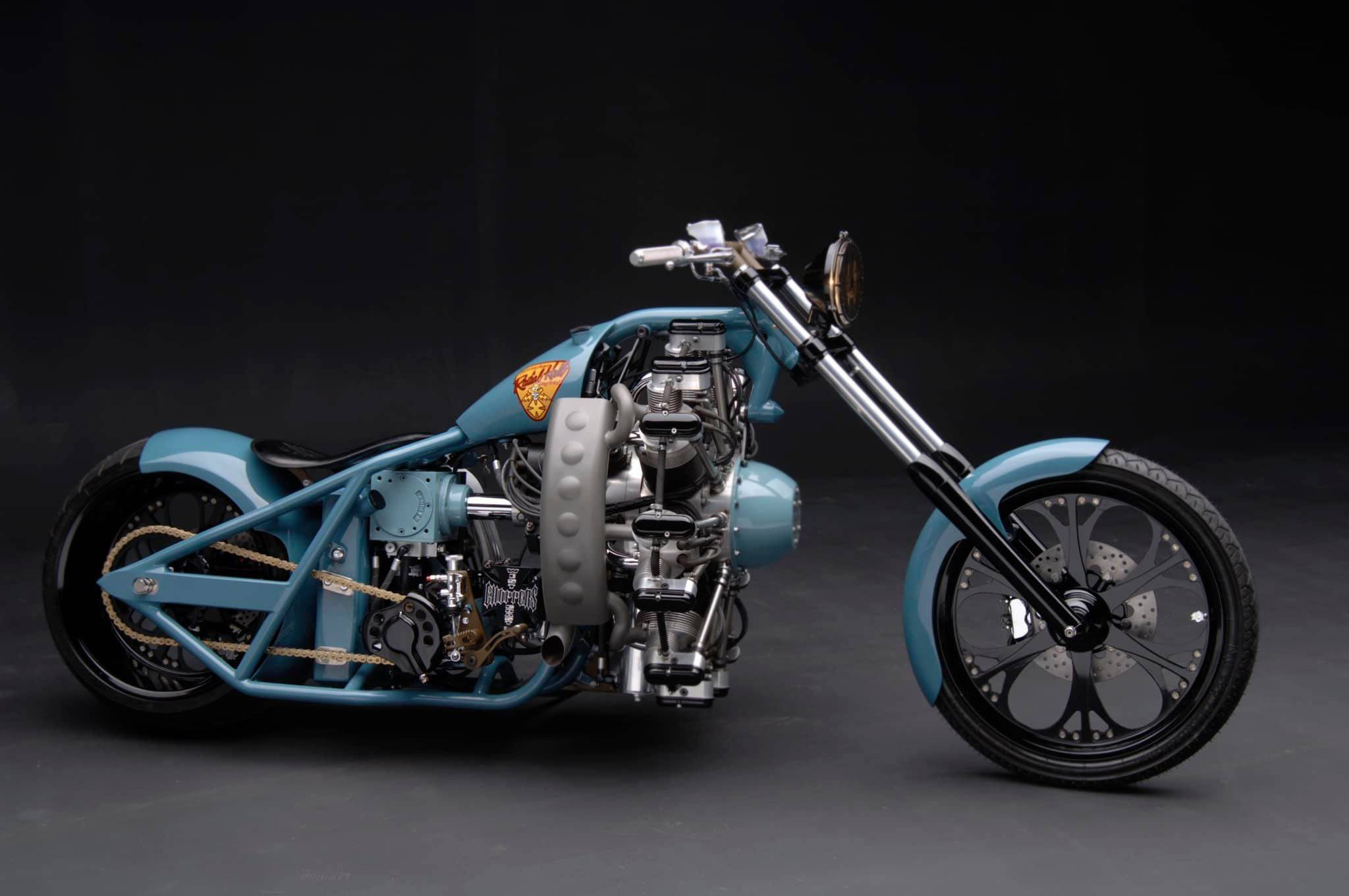 Choppers 桌布 壁紙 — 一架訂製的藍色chopper機車，配備外露引擎和鍍鉻細節，在深色攝影棚背景下展示。