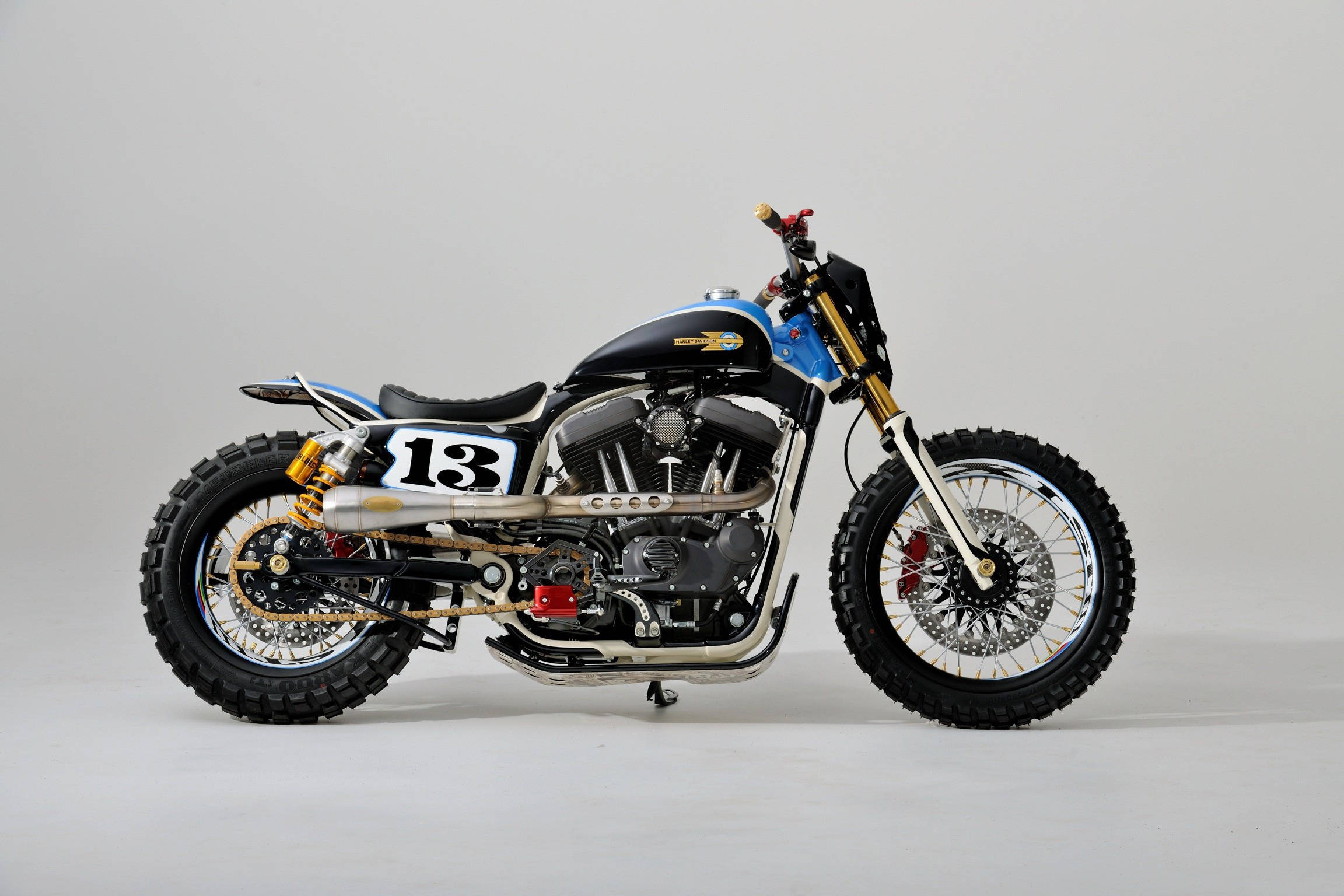 Harley 桌布 壁紙 — 一架訂製的藍黑機車，側面有13號，停在白色背景前。