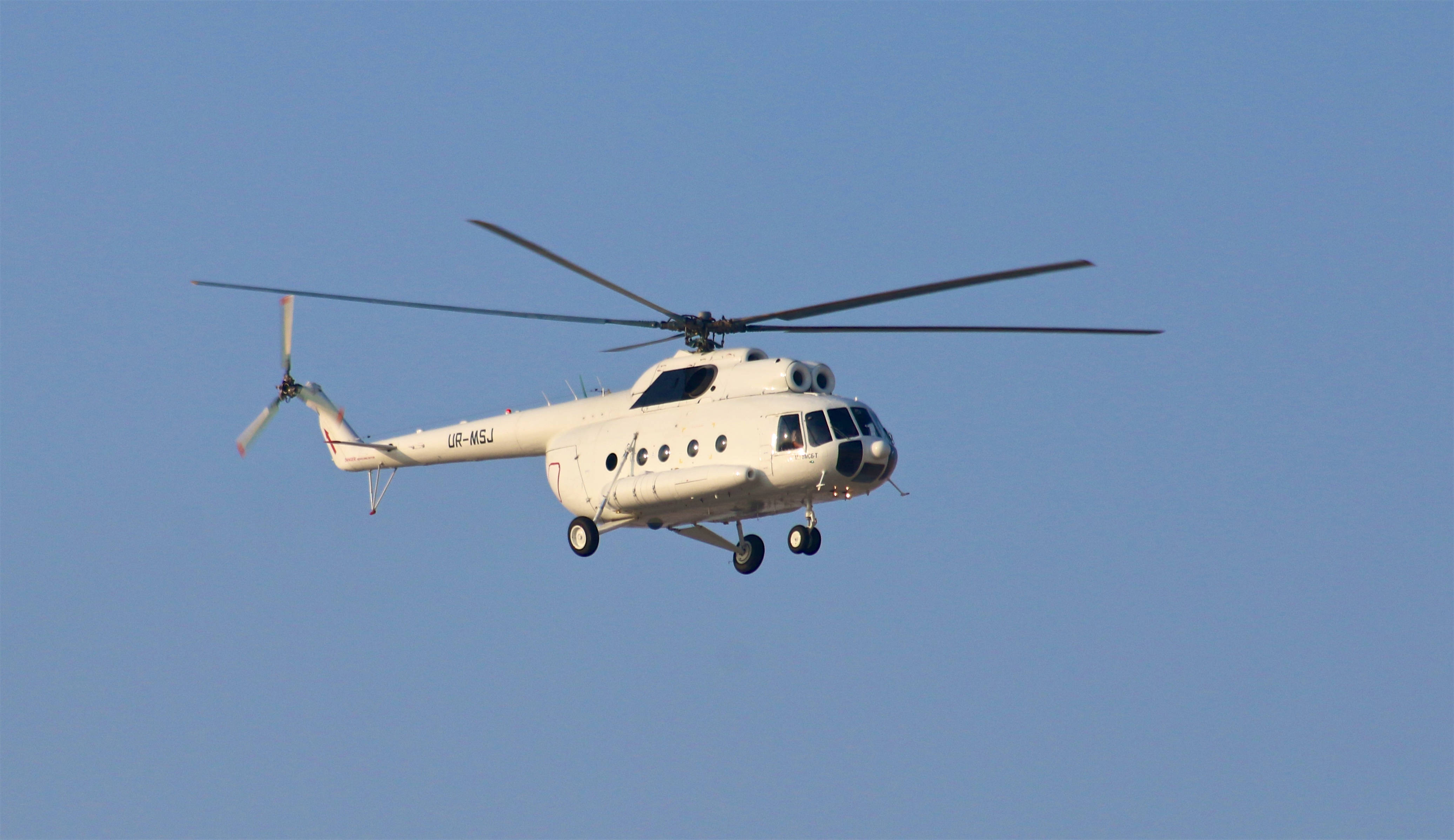 helicopter 4K 桌布 壁紙 — 一架註冊號為UR-MSJ的白色直升機在清澈的藍天中穩定翱翔。
