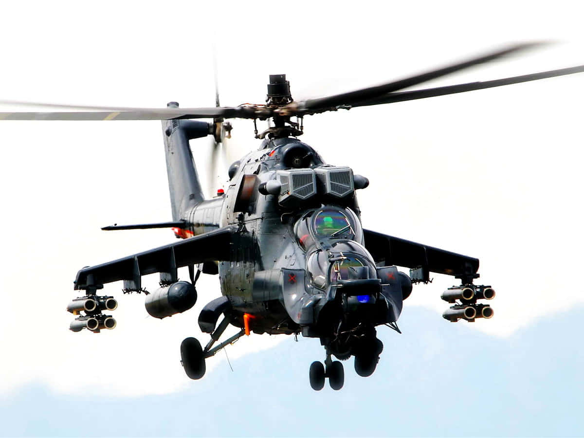 Air Force 桌布 壁紙 — 一架軍用攻擊直升機在明亮的天空下低飛，旋翼槳葉模糊，武器清晰可見。