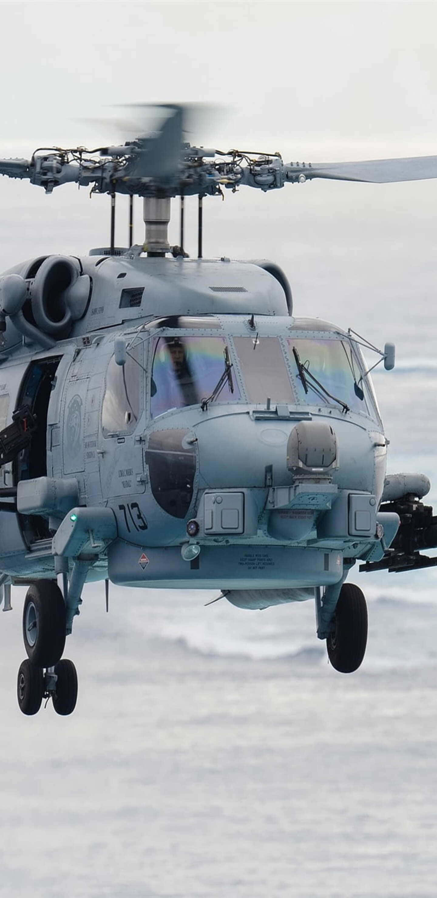 Helicopter 桌布 壁紙 — 一架軍用直升機低空盤旋在雪景之上，旋翼因運動而模糊。