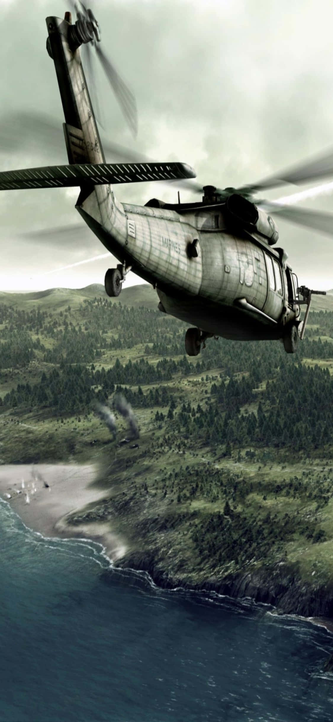 iPhone Xs Helicopters 桌布 壁紙 — 一架軍用直升機低飛過崎嶇的海岸線，有樹木繁茂的山丘和遠處從海岸升起的煙霧。