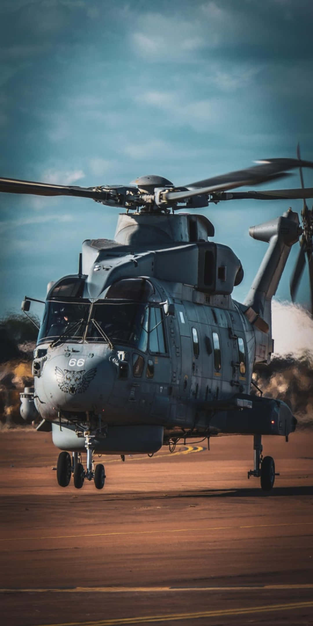 Helicopter 桌布 壁紙 — 一架軍用直升機旋轉著旋翼，停在停機坪上，背景是戲劇性的多雲天空。