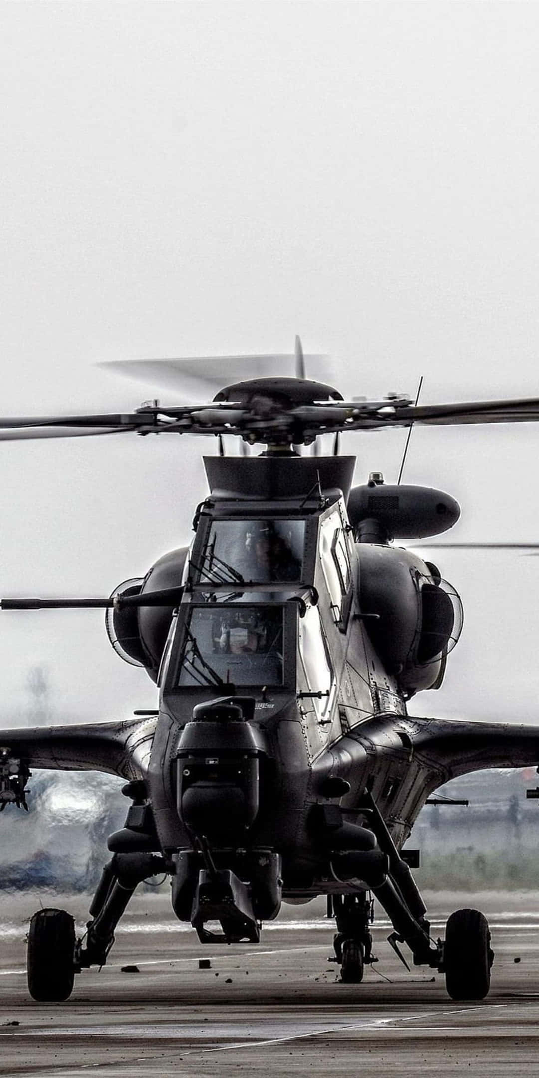 Helicopter 桌布 壁紙 — 一架軍用直升機旋轉著螺旋槳，停在停機坪上，天空多雲，黑白畫面。