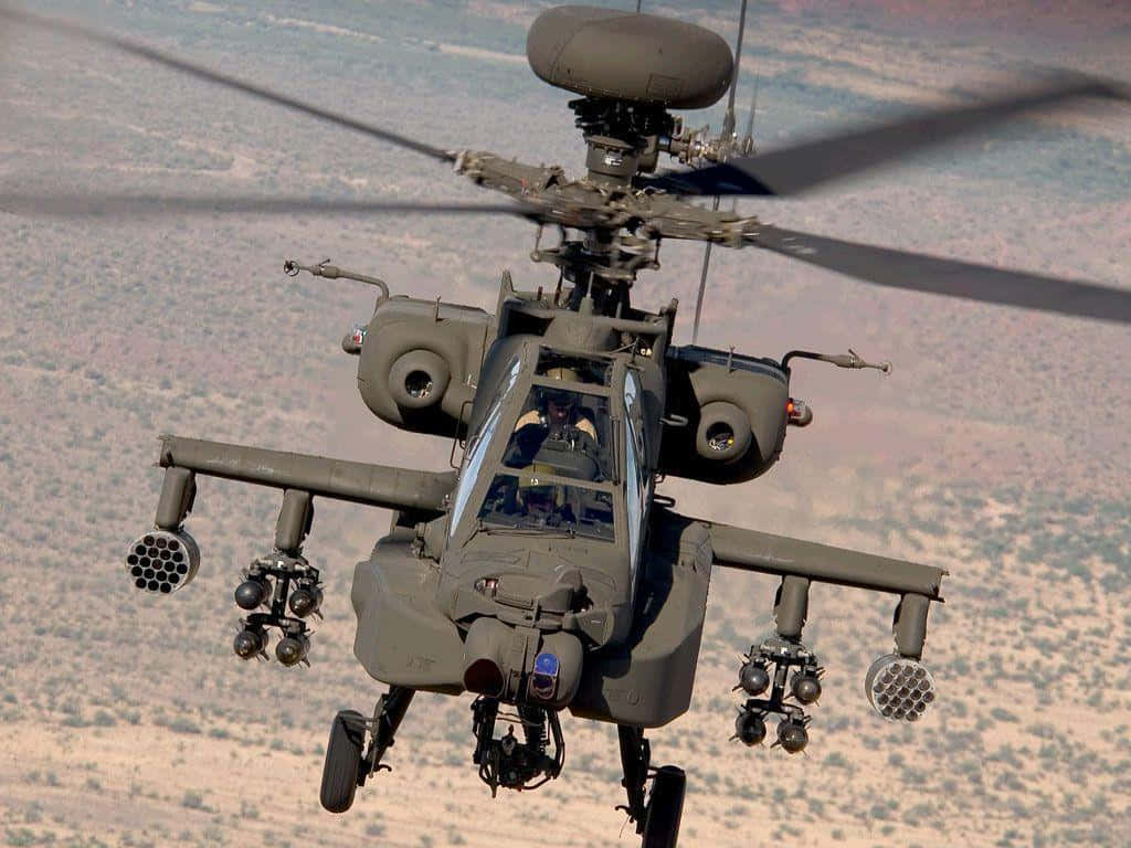 Helicopter 桌布 壁紙 — 一架軍用阿帕契攻擊直升機低飛過荒蕪的沙漠景觀，旋翼轉動，機載武器清晰可見。