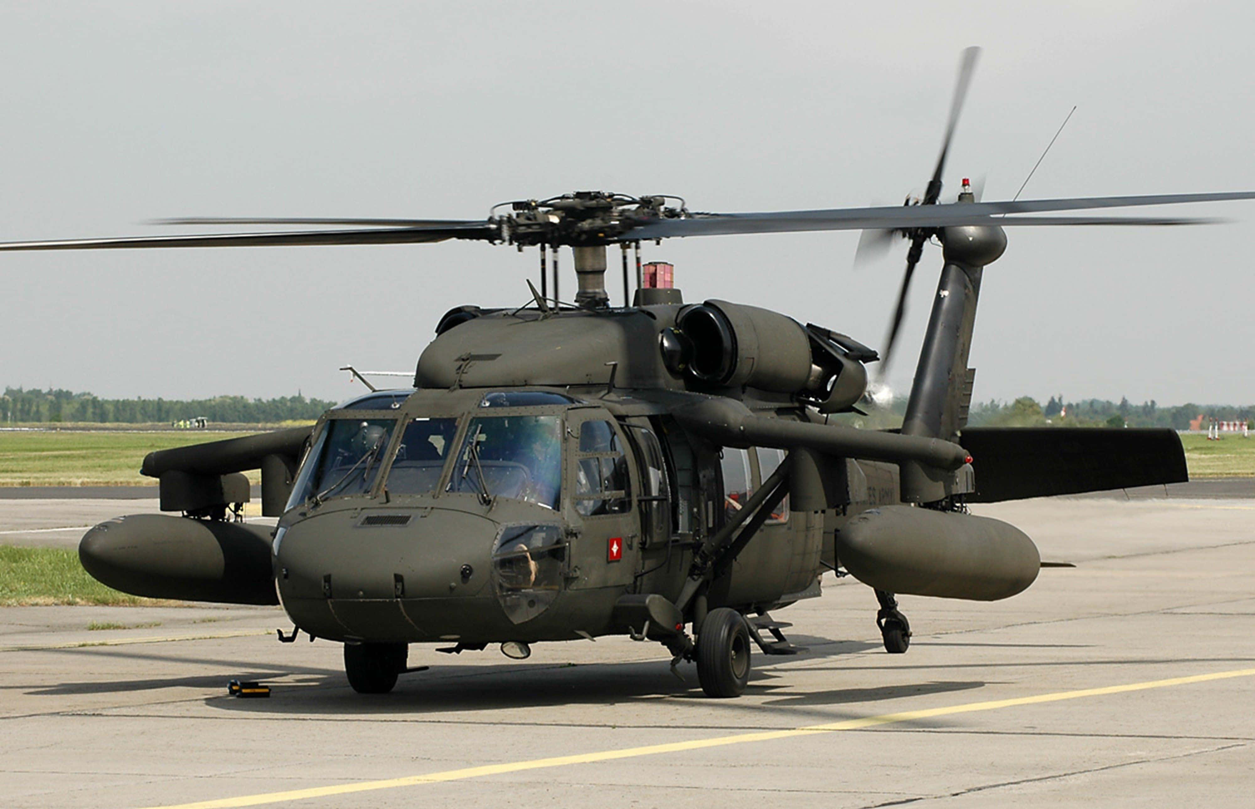 Helicopter 桌布 壁紙 — 一架軍用黑色直升機在陰天停機坪上旋轉著旋翼。