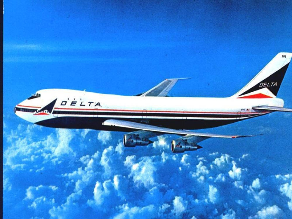 飛機 桌布 壁紙 — 一架達美航空的波音747在充滿活力的藍天下優雅地翱翔於蓬鬆的白雲之上。