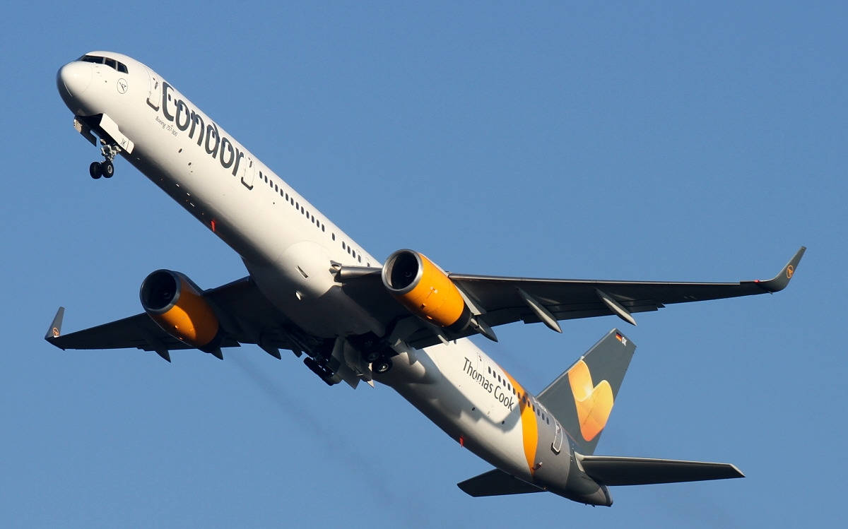  壁紙 — 一架配備橙色引擎的Condor Thomas Cook飛機在清澈的藍天中上升。