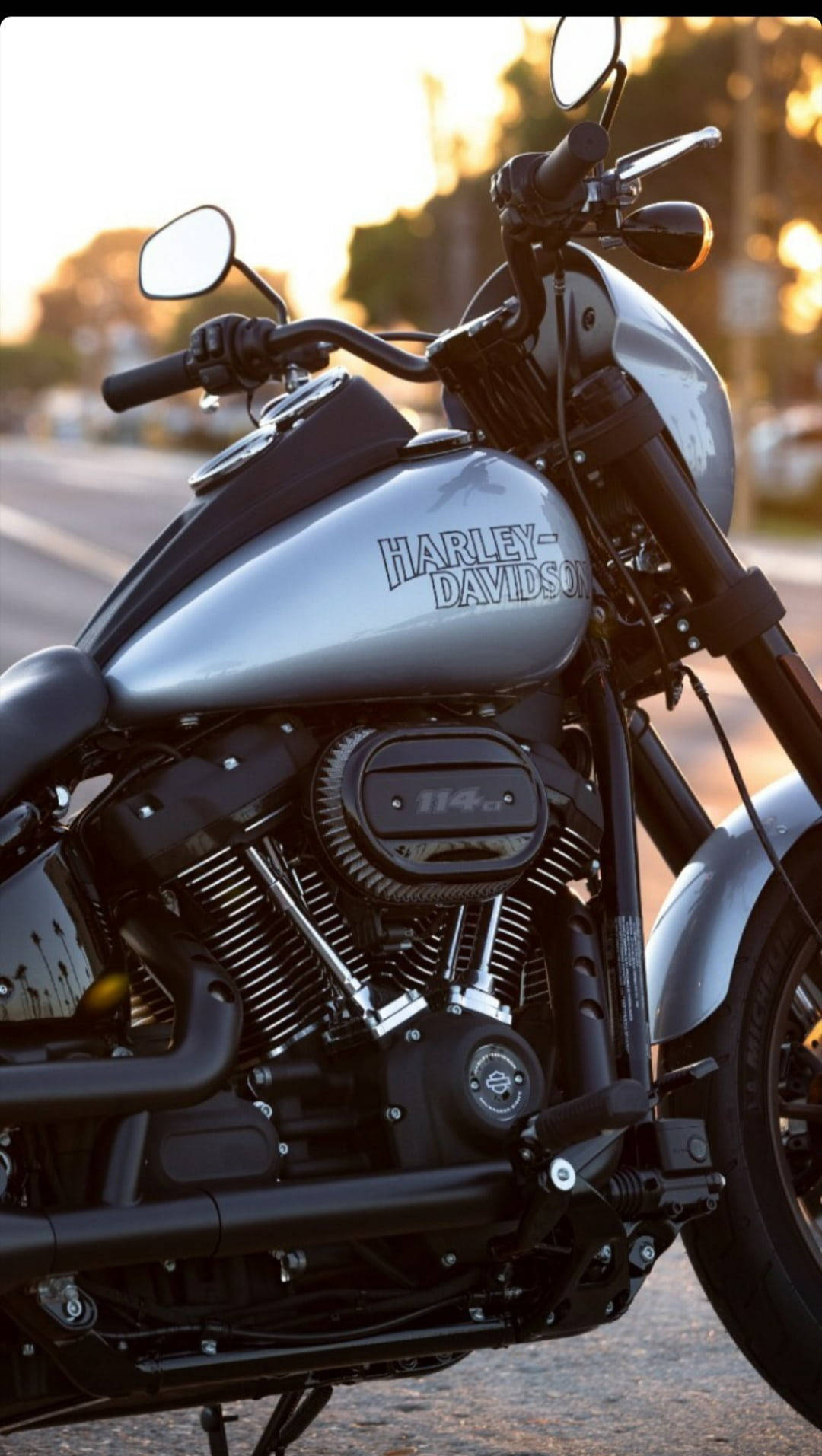 銀色Harley-Davidson摩托車在日落時停放在道路上。