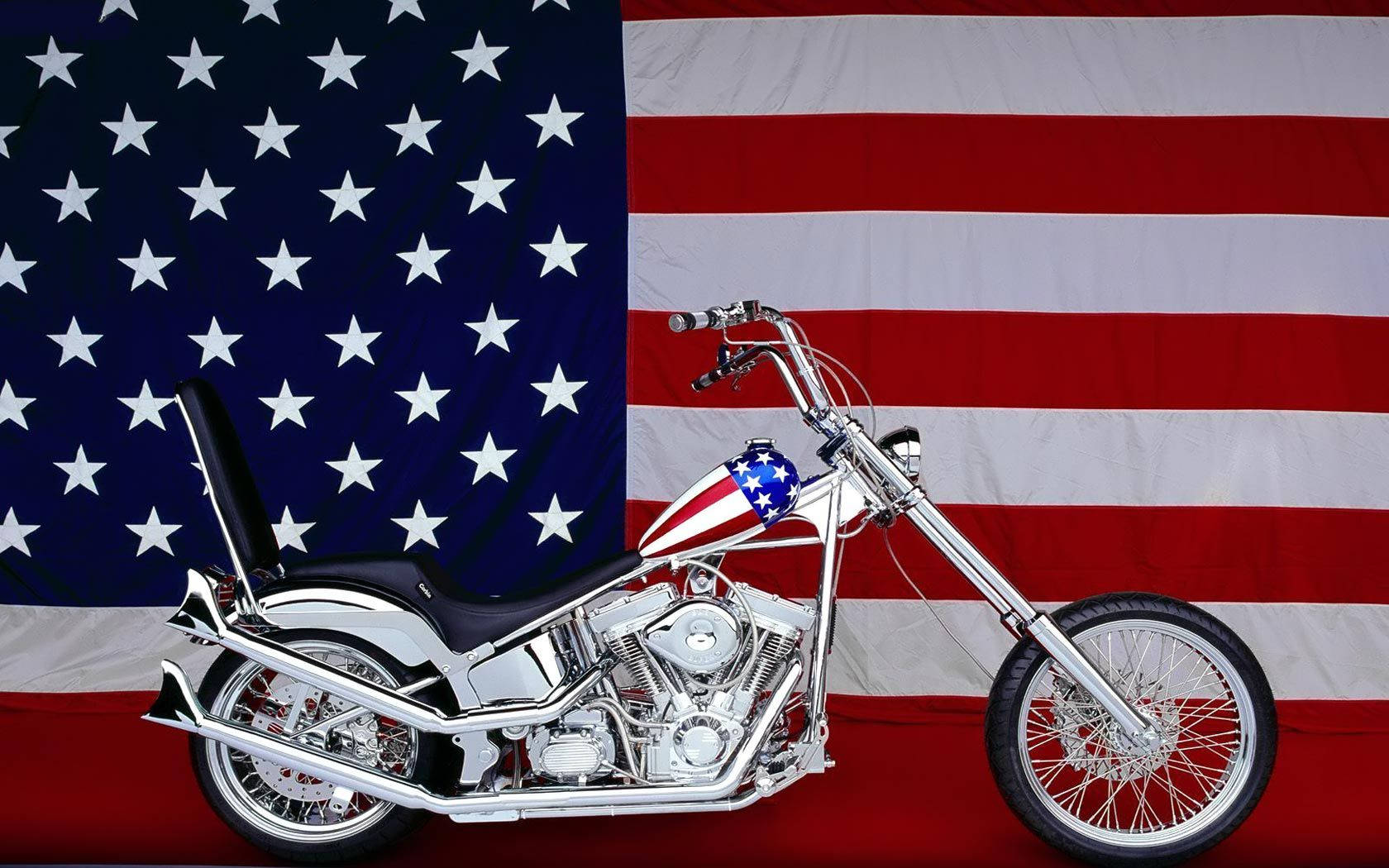 Harley 桌布 壁紙 — 一架鍍鉻的chopper機車帶有美國國旗圖案，自豪地矗立在大型美國國旗背景前。