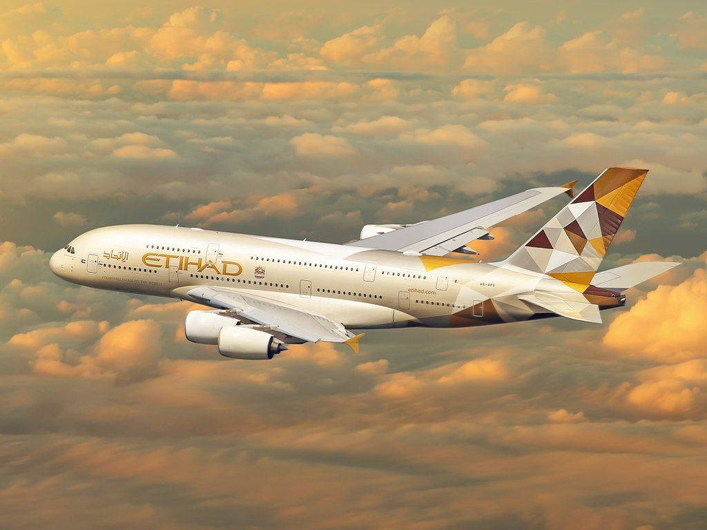  壁紙 — 一架阿提哈德航空的空中巴士A380在溫暖夕陽照耀的金色雲海上優雅翱翔。