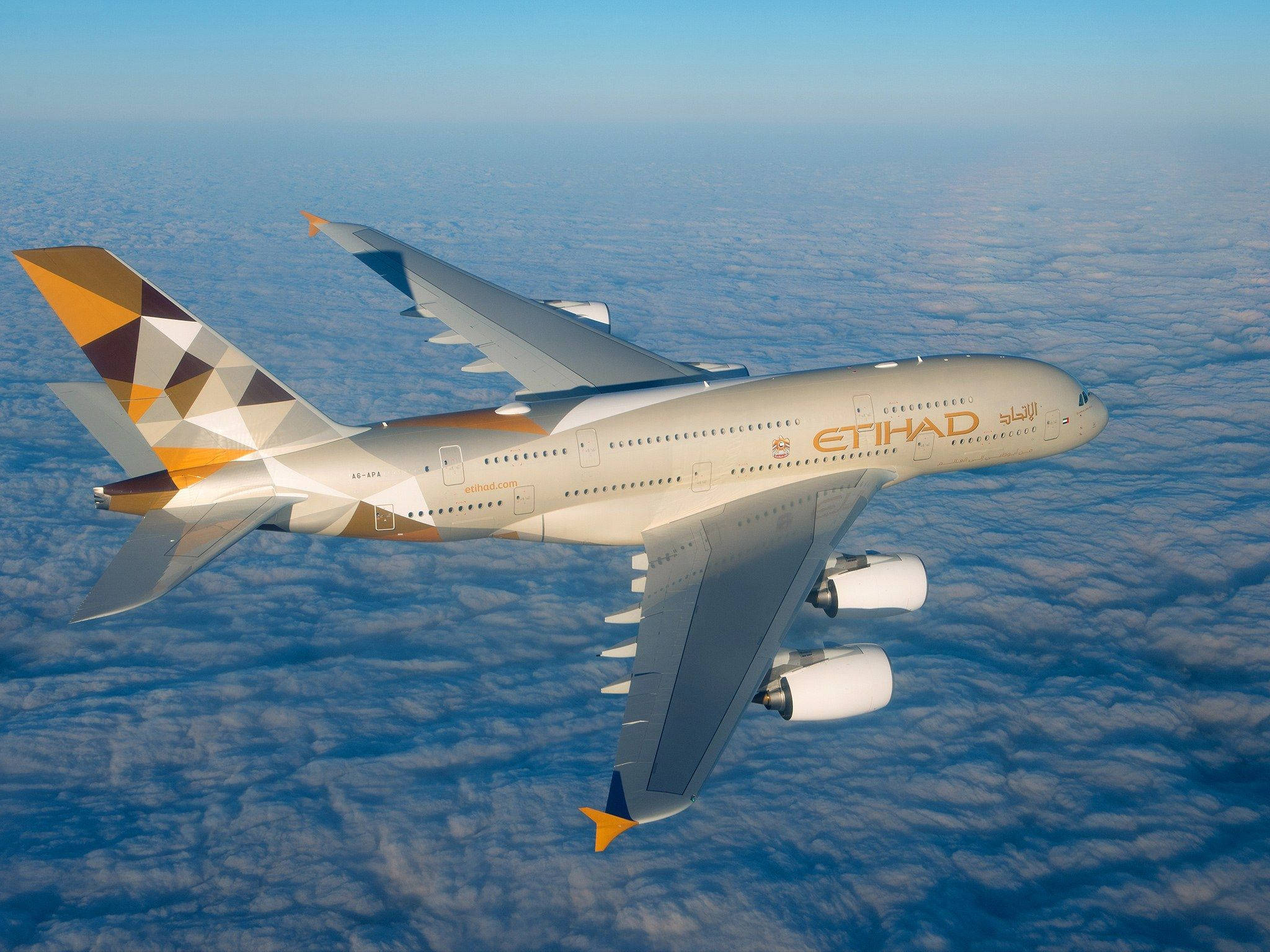 Blue Sky 桌布 壁紙 — 一架阿提哈德航空的空中巴士A380在晴朗的藍天下，翱翔於廣闊的 fluffy 白雲海洋之上。