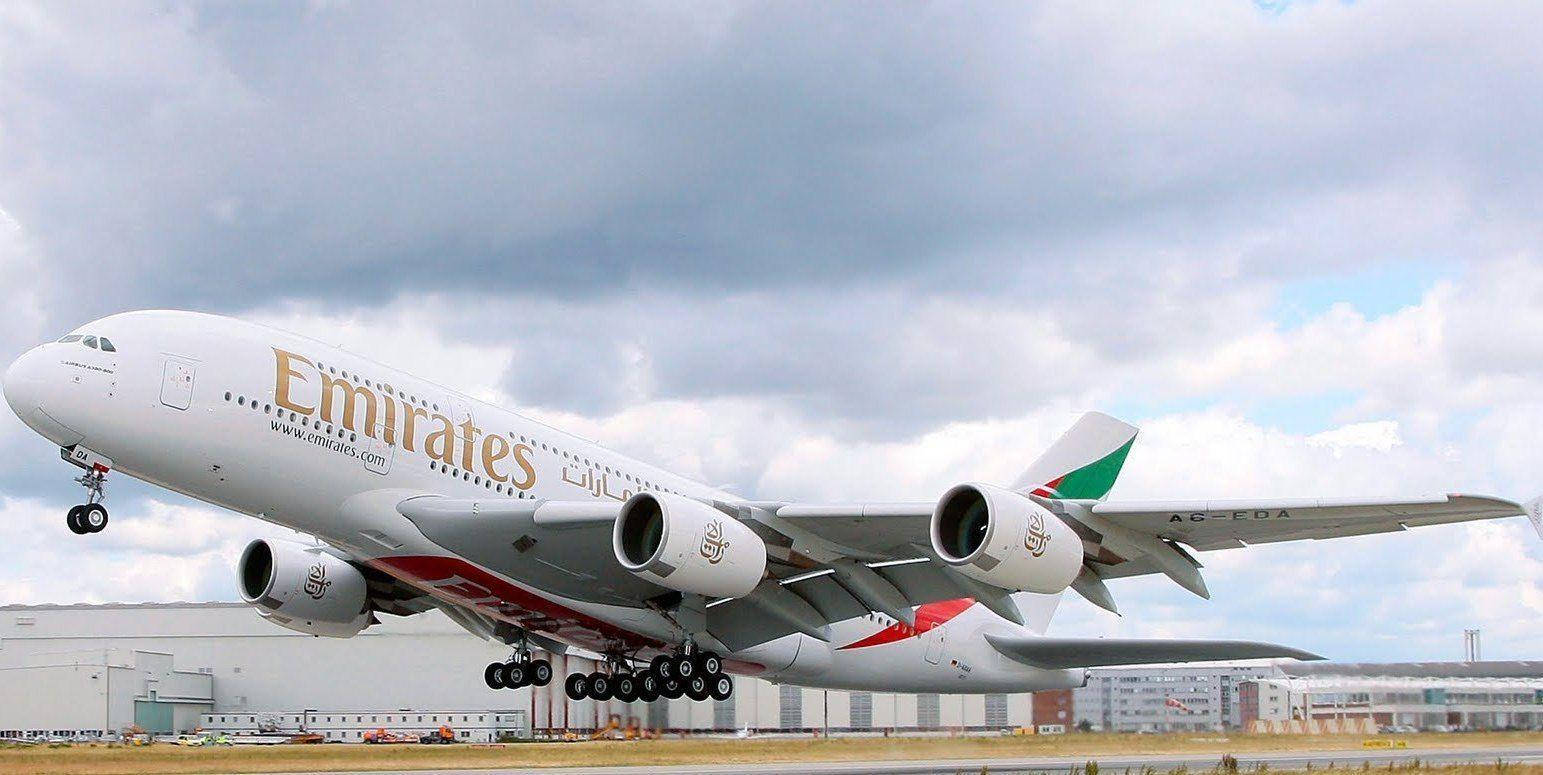 Airport 桌布 壁紙 — 一架阿聯酋航空空中巴士A380在多雲的天空下起飛，背景是機場建築物。