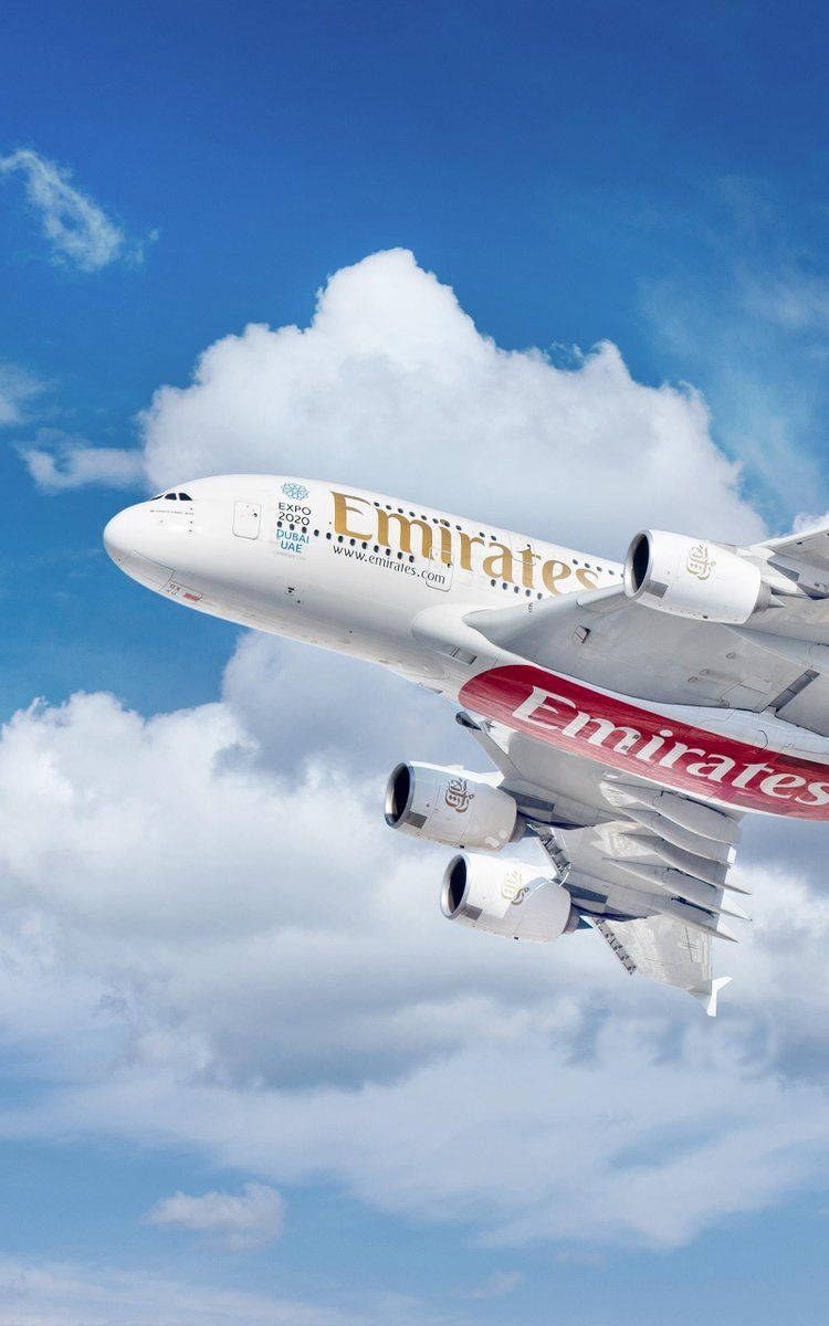 飛機 桌布 壁紙 — 一架阿聯酋航空空中巴士A380在點綴著蓬鬆白雲的明亮藍天中優雅翱翔。