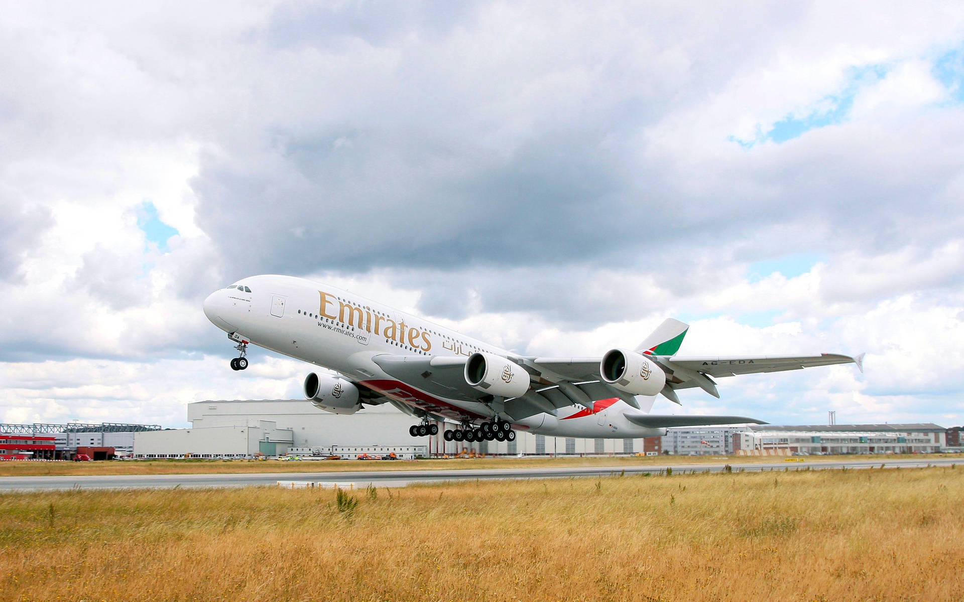 雲朵 桌布 壁紙 — 一架阿聯酋航空空中巴士A380從跑道起飛，上空有雲，下方有乾草。