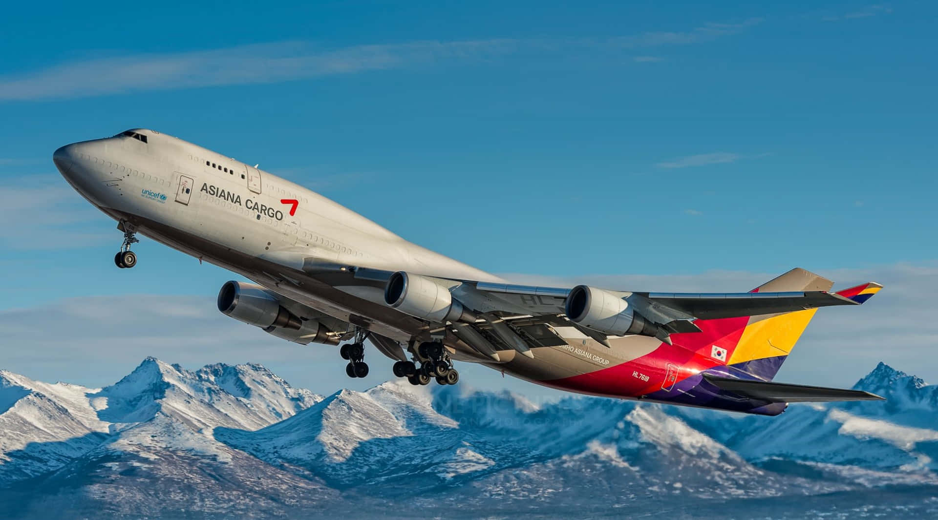 飛機 桌布 壁紙 — 一架韓亞航空貨運波音747在晴朗藍天下，起落架放下，翱翔在積雪山脈之上。