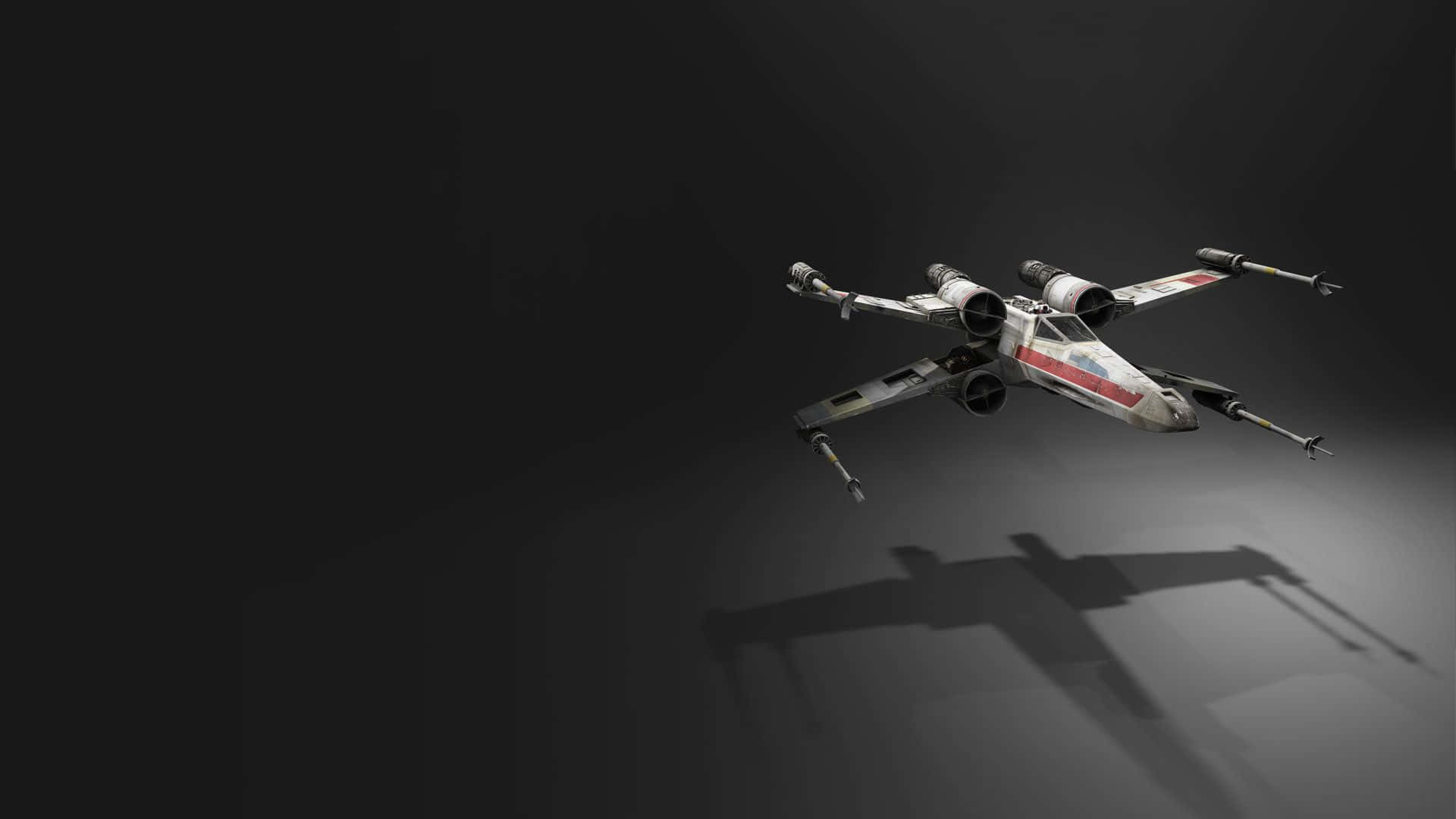 X-wing Fighter 桌布 壁紙 — 一架風化的X翼星際戰鬥機在黑暗的攝影棚空間中滑行，在灰色地板上投下清晰的陰影。