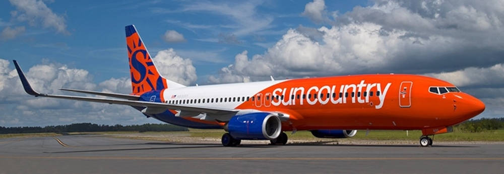 Sun Country飛機在多雲天空下的跑道 — 寬螢幕動態圖片 壁紙